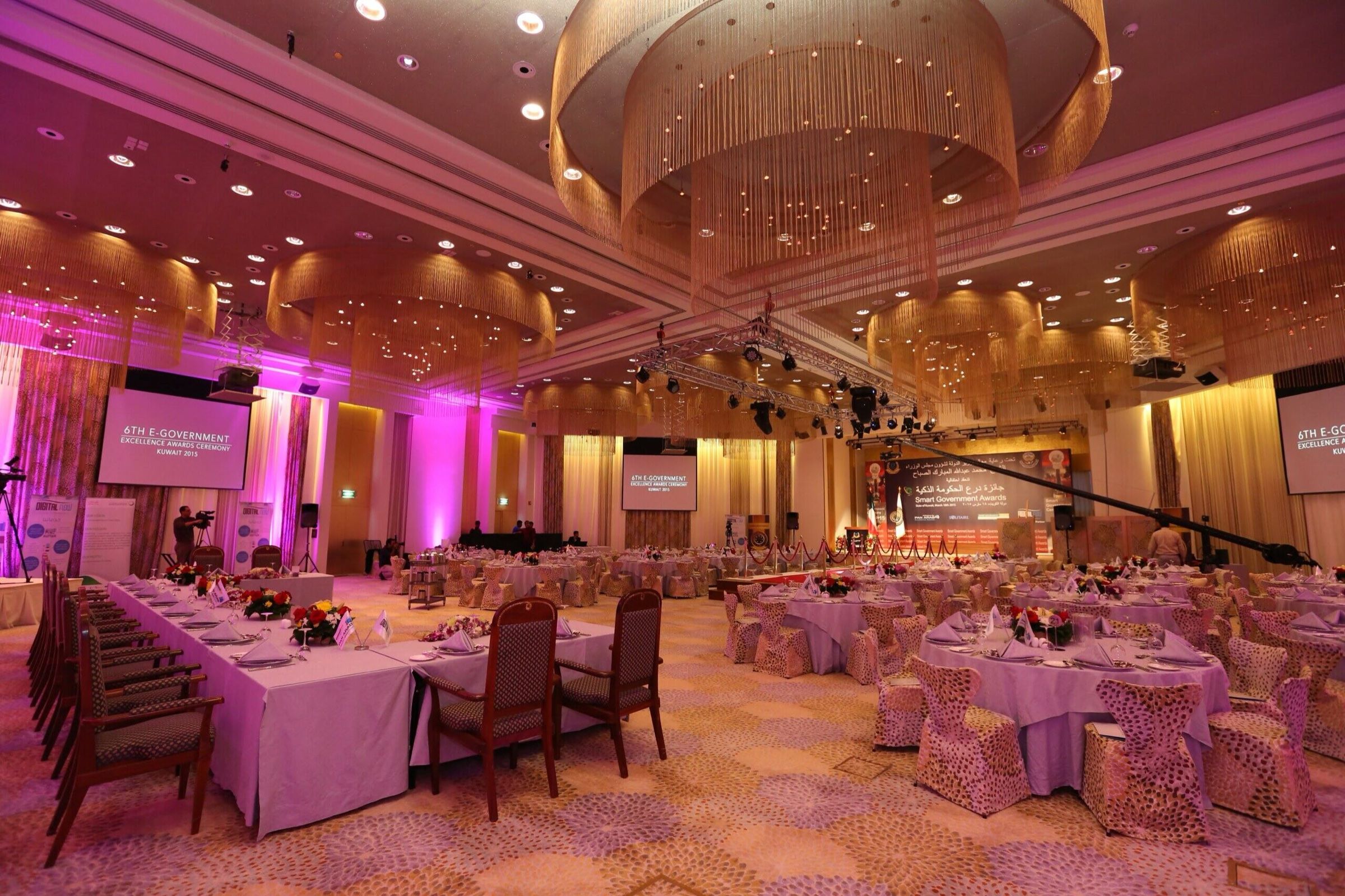 Hotel ballroom decorated for a gala dinner with purple uplighting
