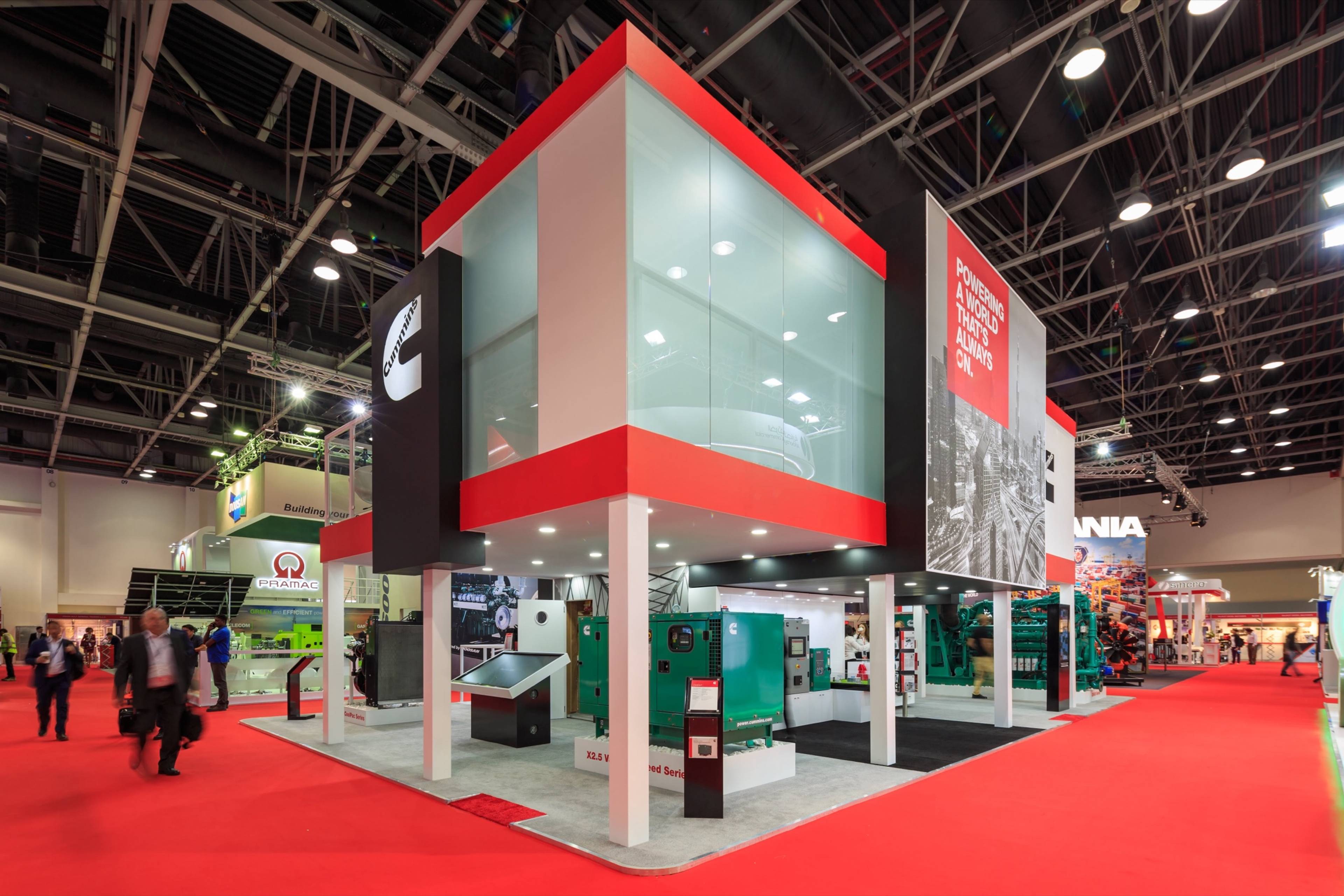 Double-decker exhibition stand in red and white at a Dubai trade show