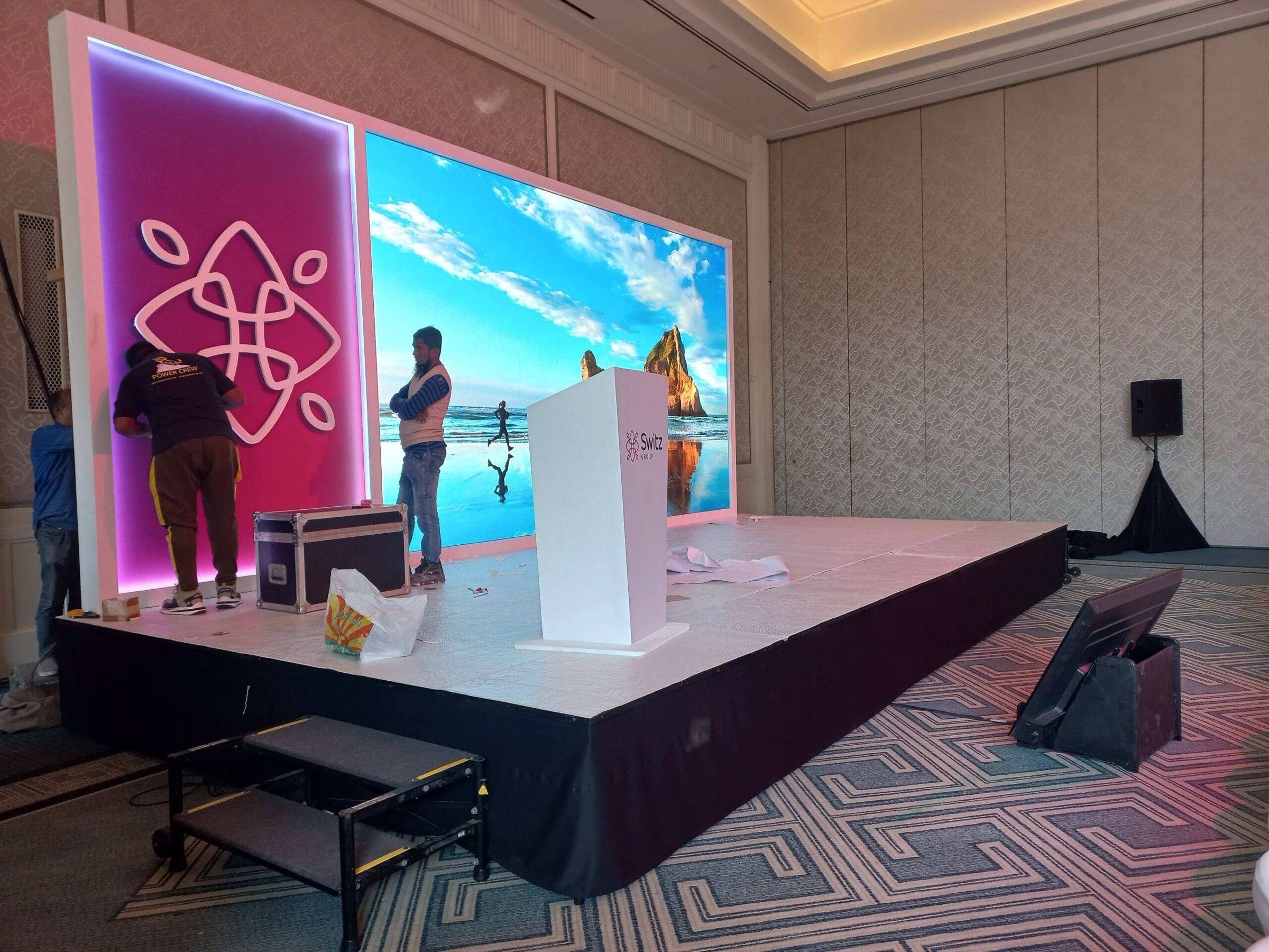 Stage with a podium and colourful LED screen before a corporate event