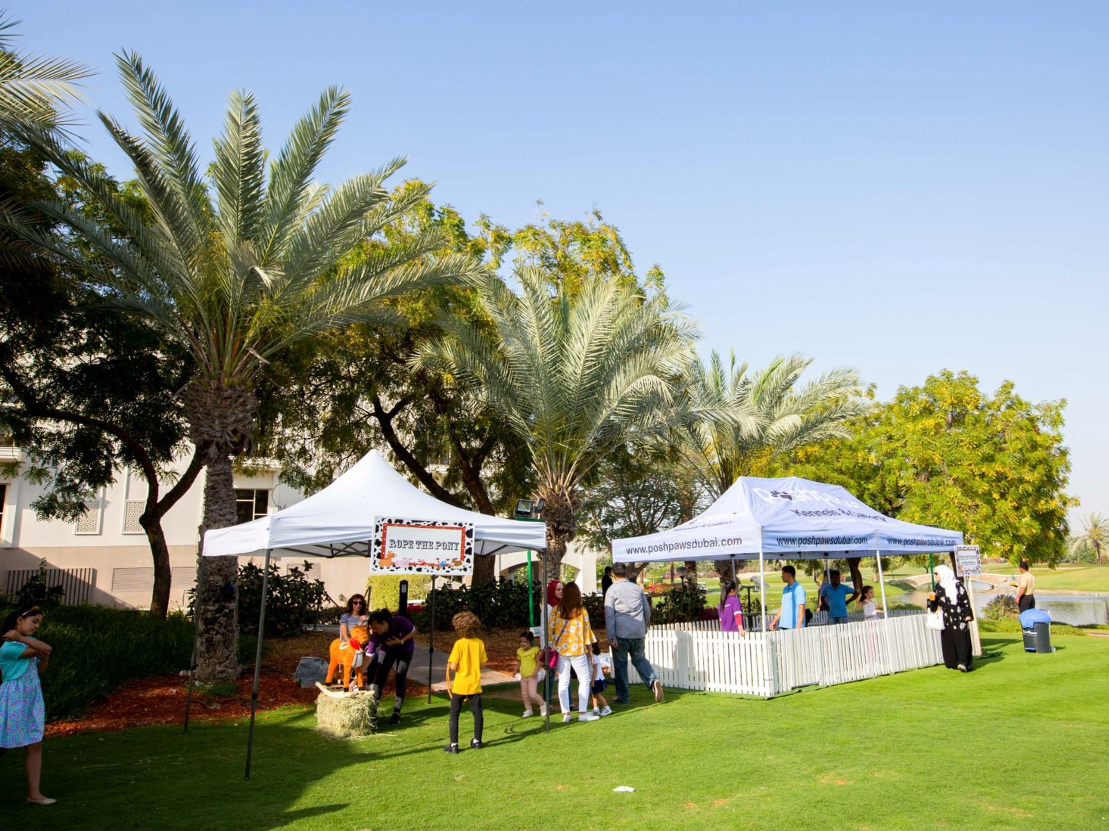 Carnival gazebos and game stalls on the lawn at the Bioderma family day, Address Montgomerie, Dubai
