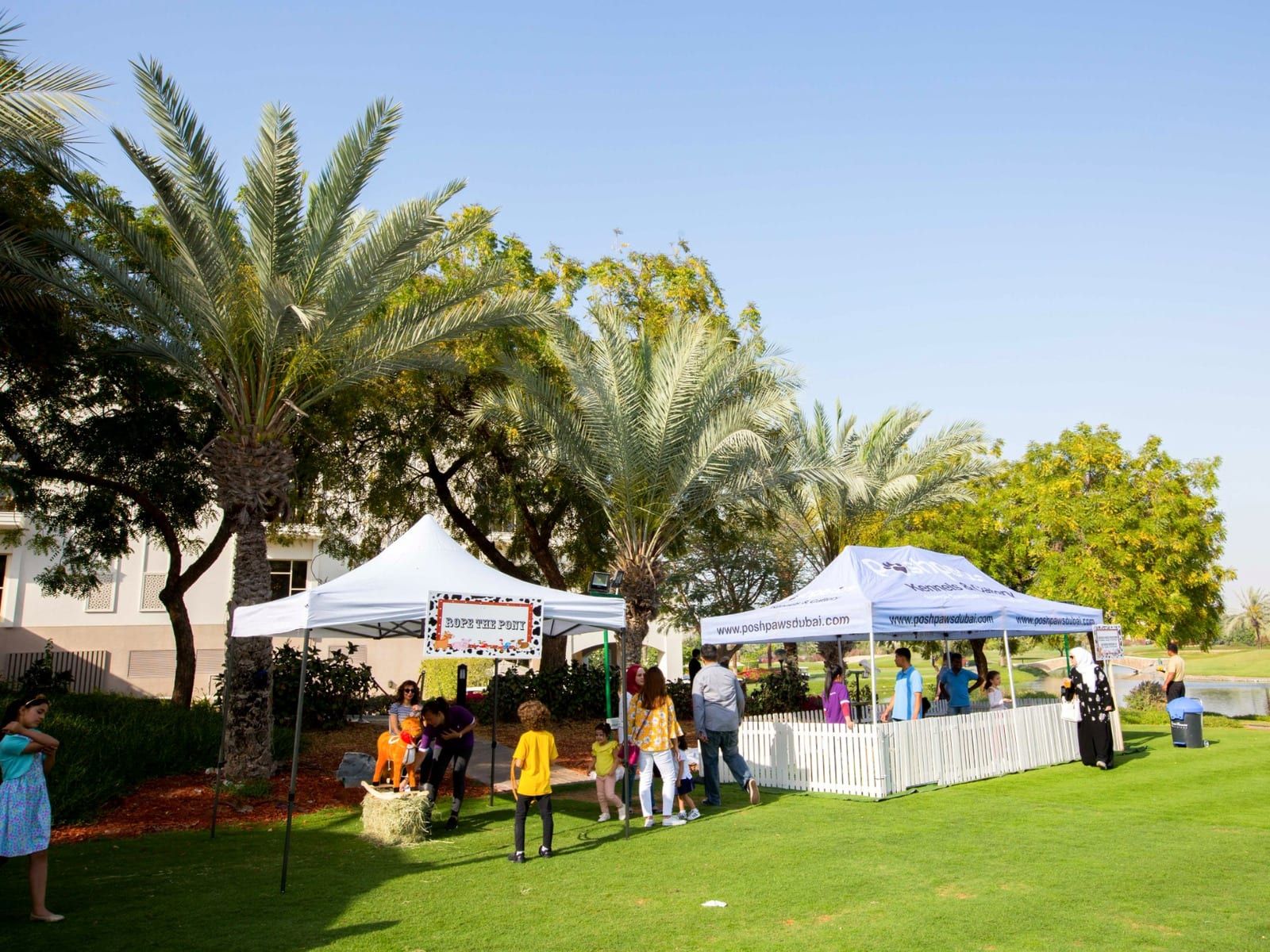 Carnival gazebos and game stalls on the lawn at the Bioderma family day, Address Montgomerie, Dubai