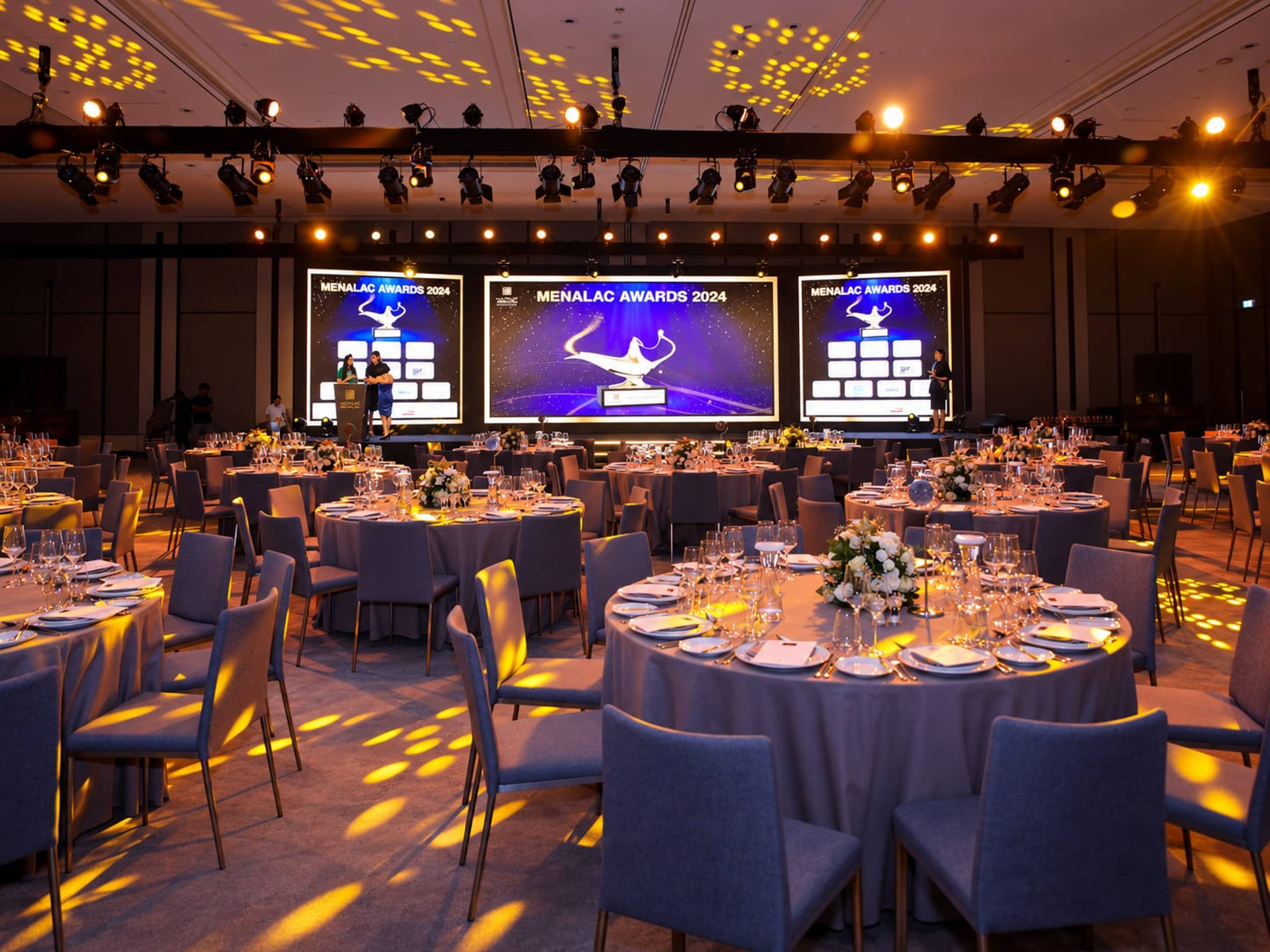 MENALAC Awards 2024 gala ballroom with round tables and LED screens at Sky View Dubai