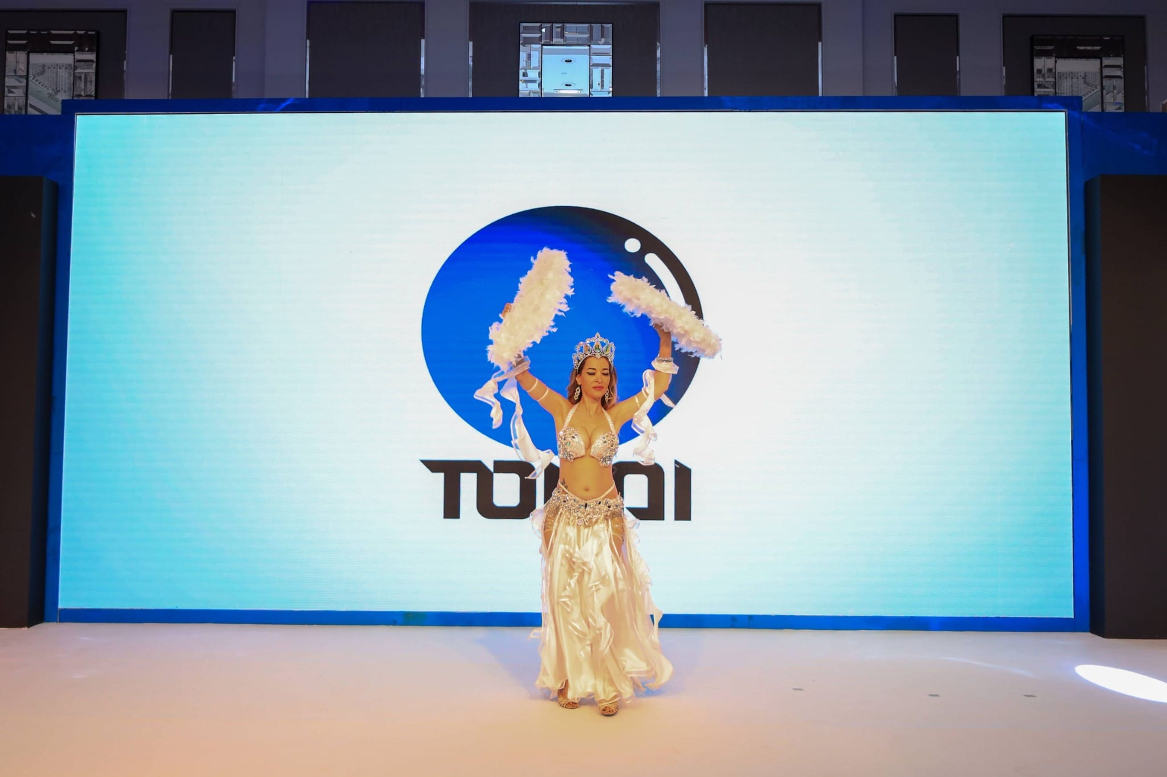 Dancer performing on stage in front of the Tokai logo screen