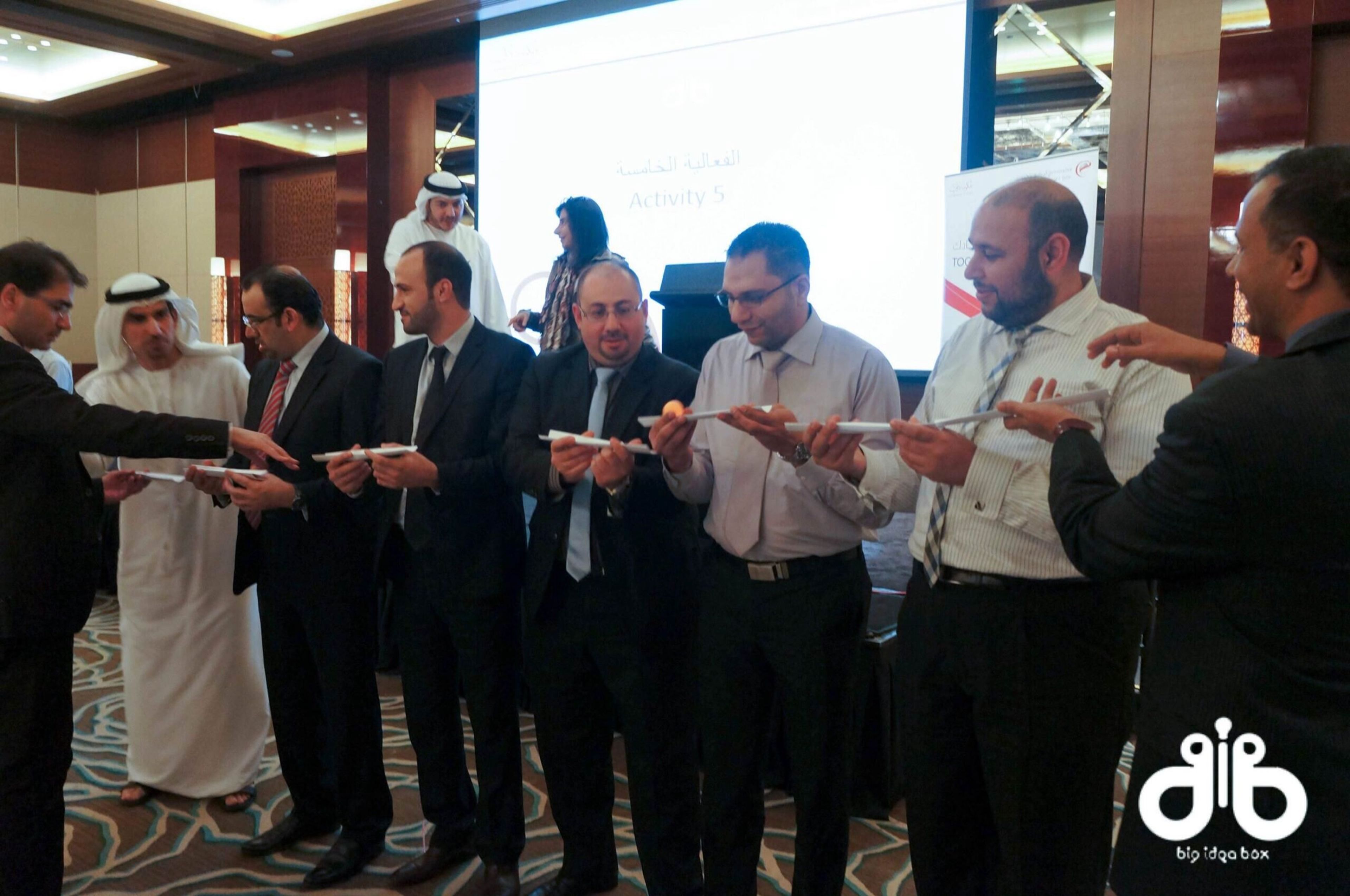 Guests joining hands at a ceremonial moment during a corporate event