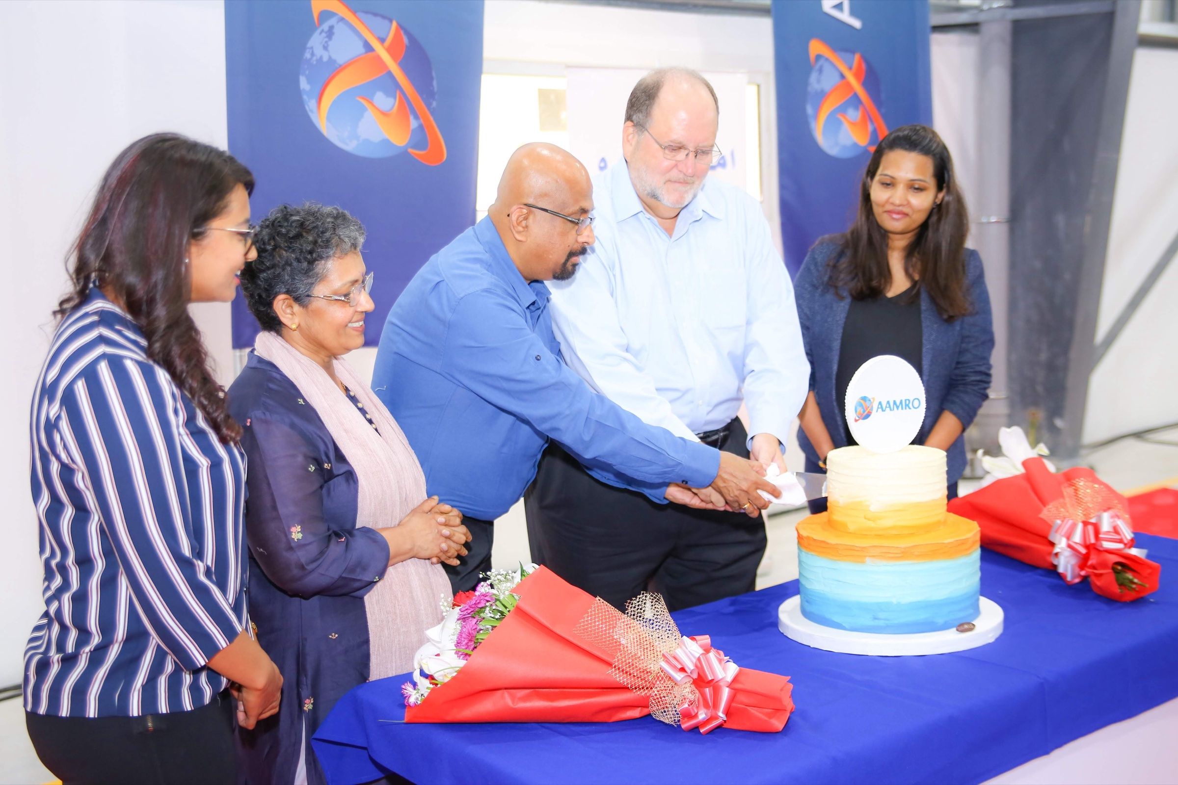 Executives cutting a celebration cake at a company opening