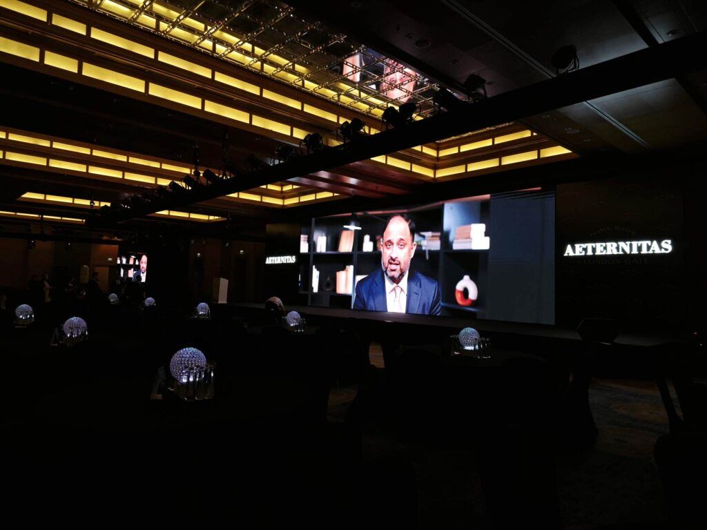 Dark event space with a screen showing a watch brand presentation