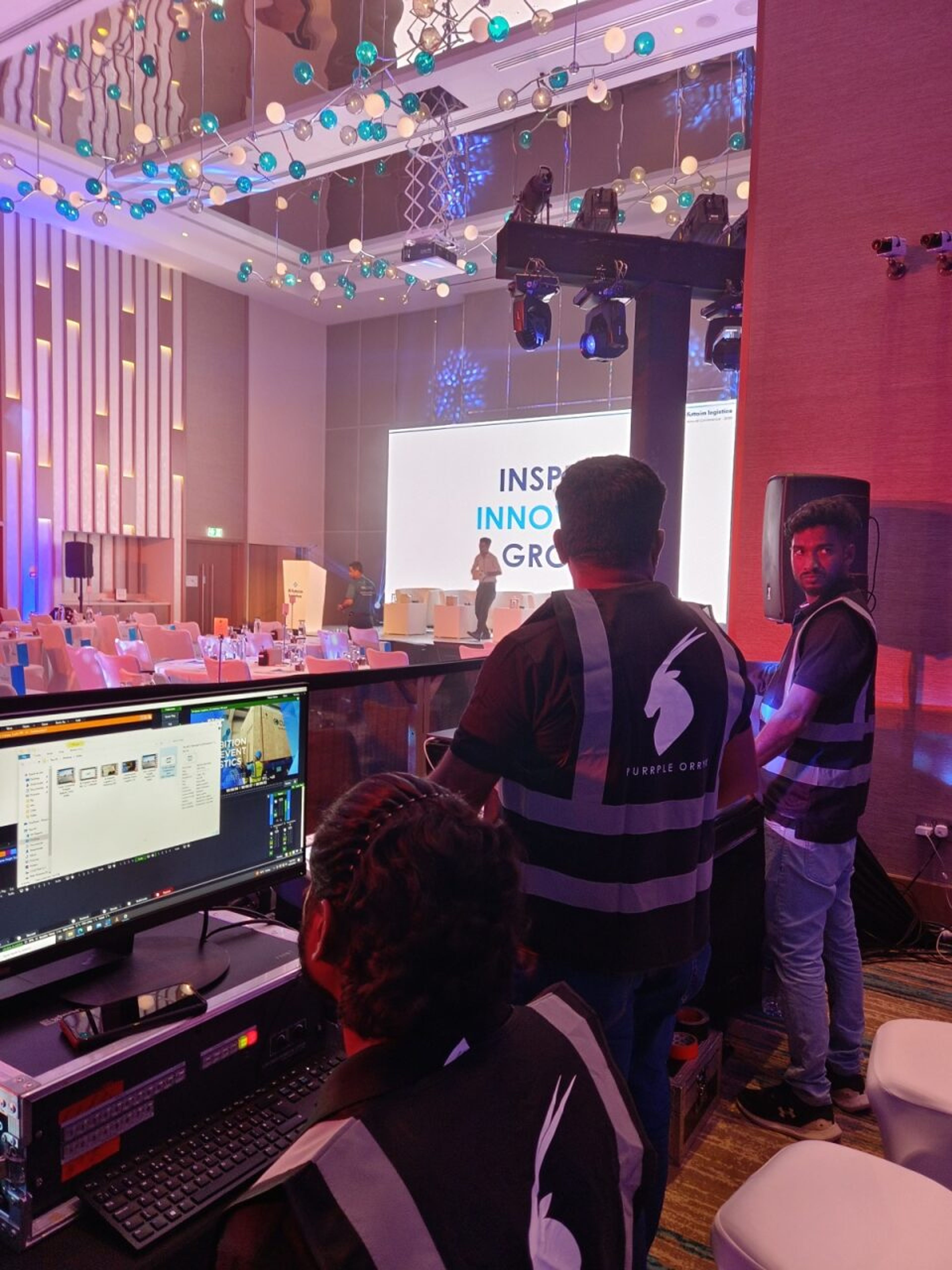 Purrple Orryx technical crew at the control desk during a corporate conference, with the LED screen and speaker on stage behind