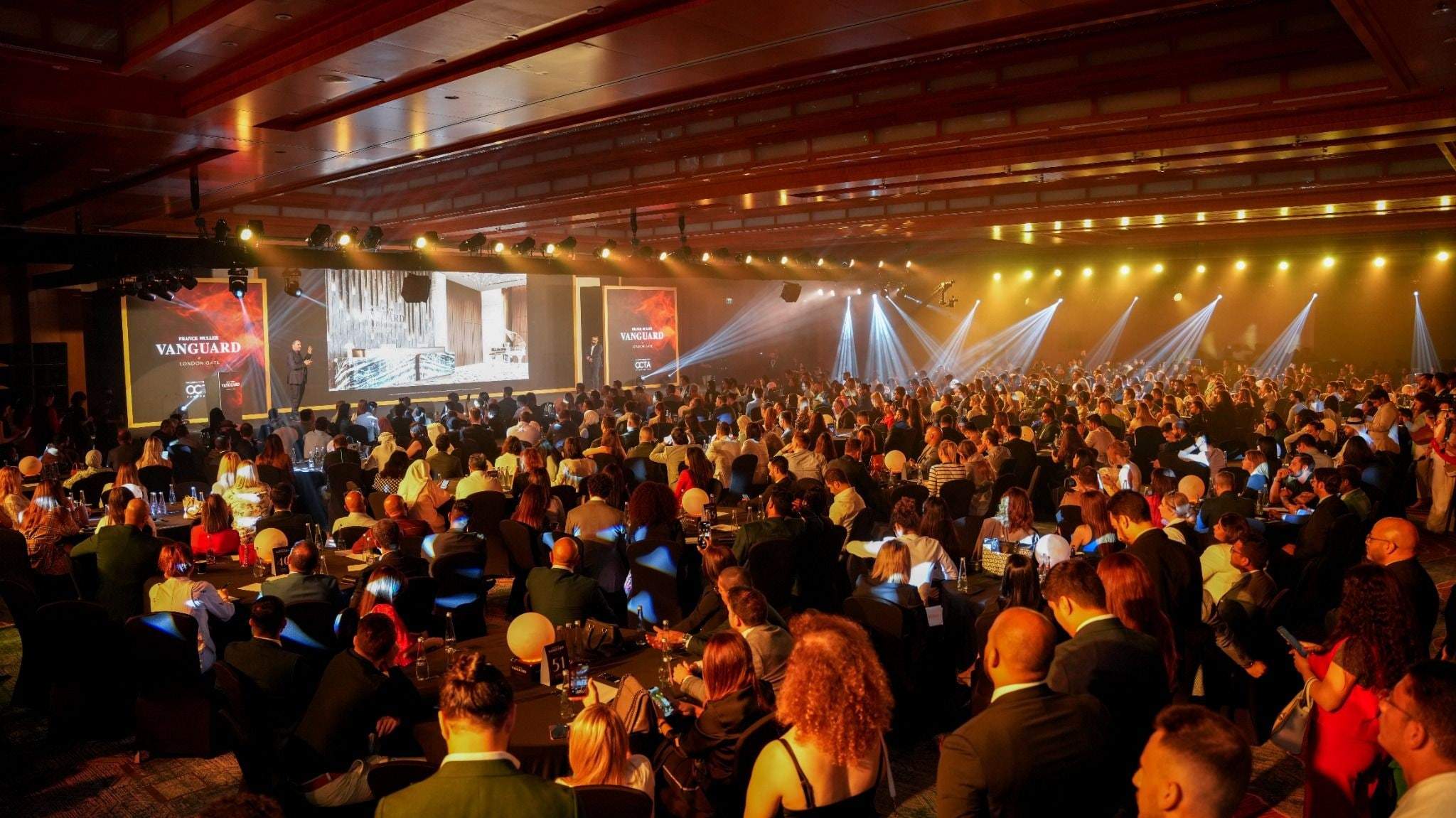 Full ballroom of guests under warm stage lighting at the Franck Muller Vanguard launch, The Ritz-Carlton DIFC
