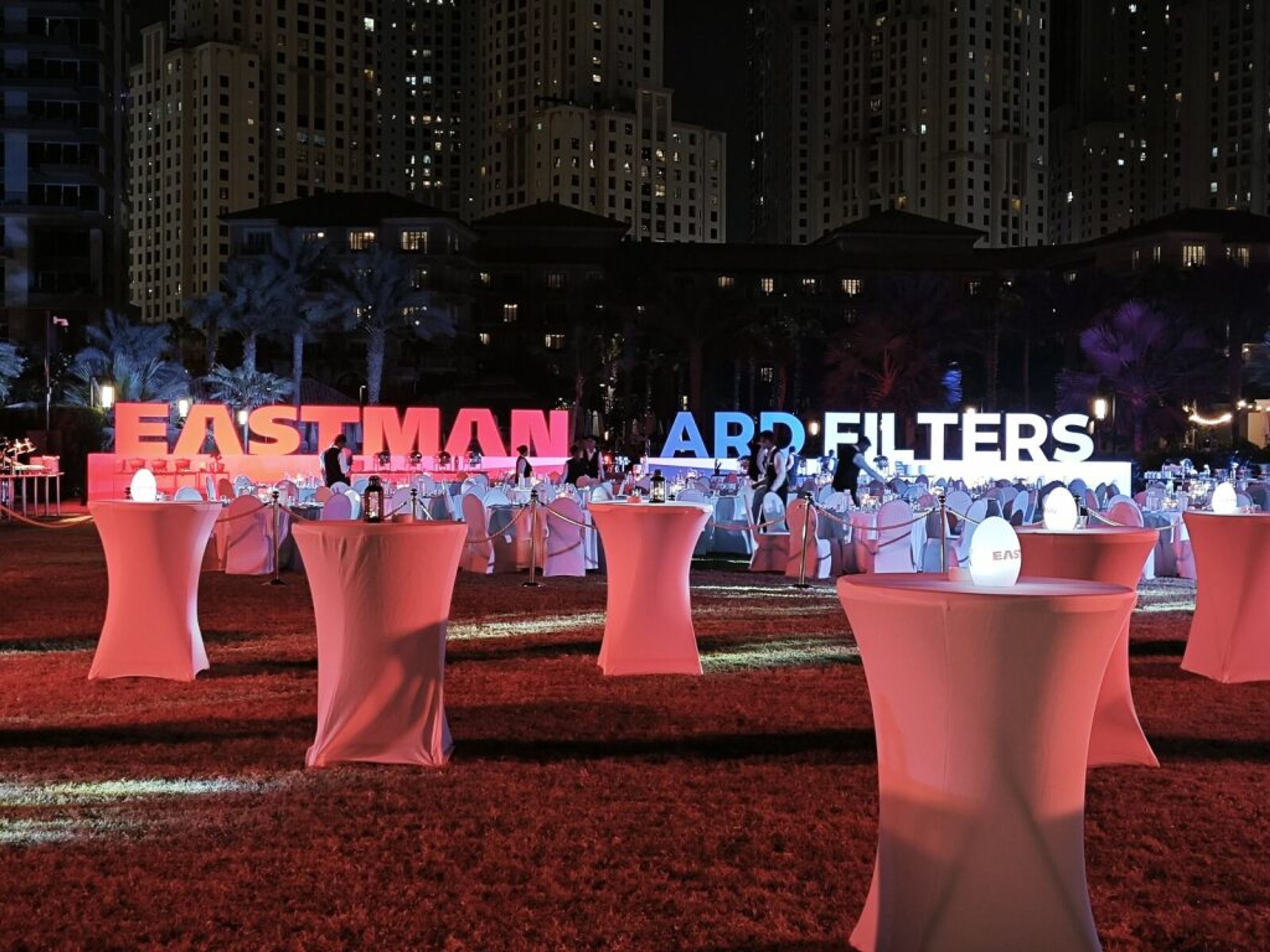 Outdoor evening event with branded letters and cocktail tables