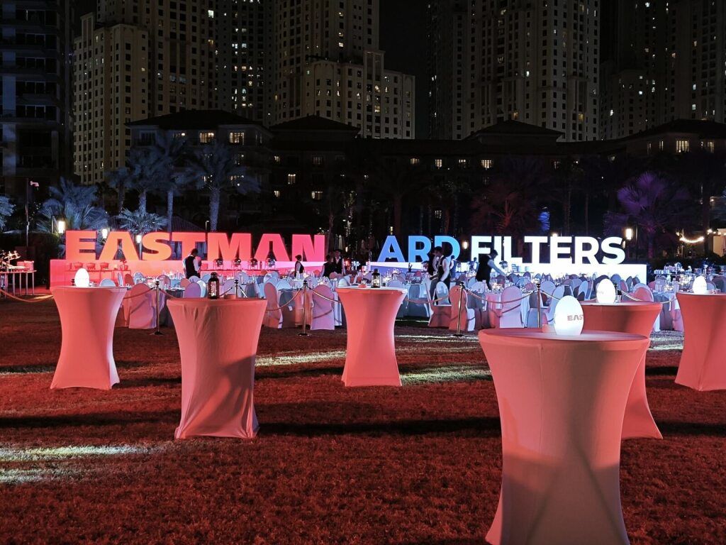 Outdoor evening event with branded letters and cocktail tables