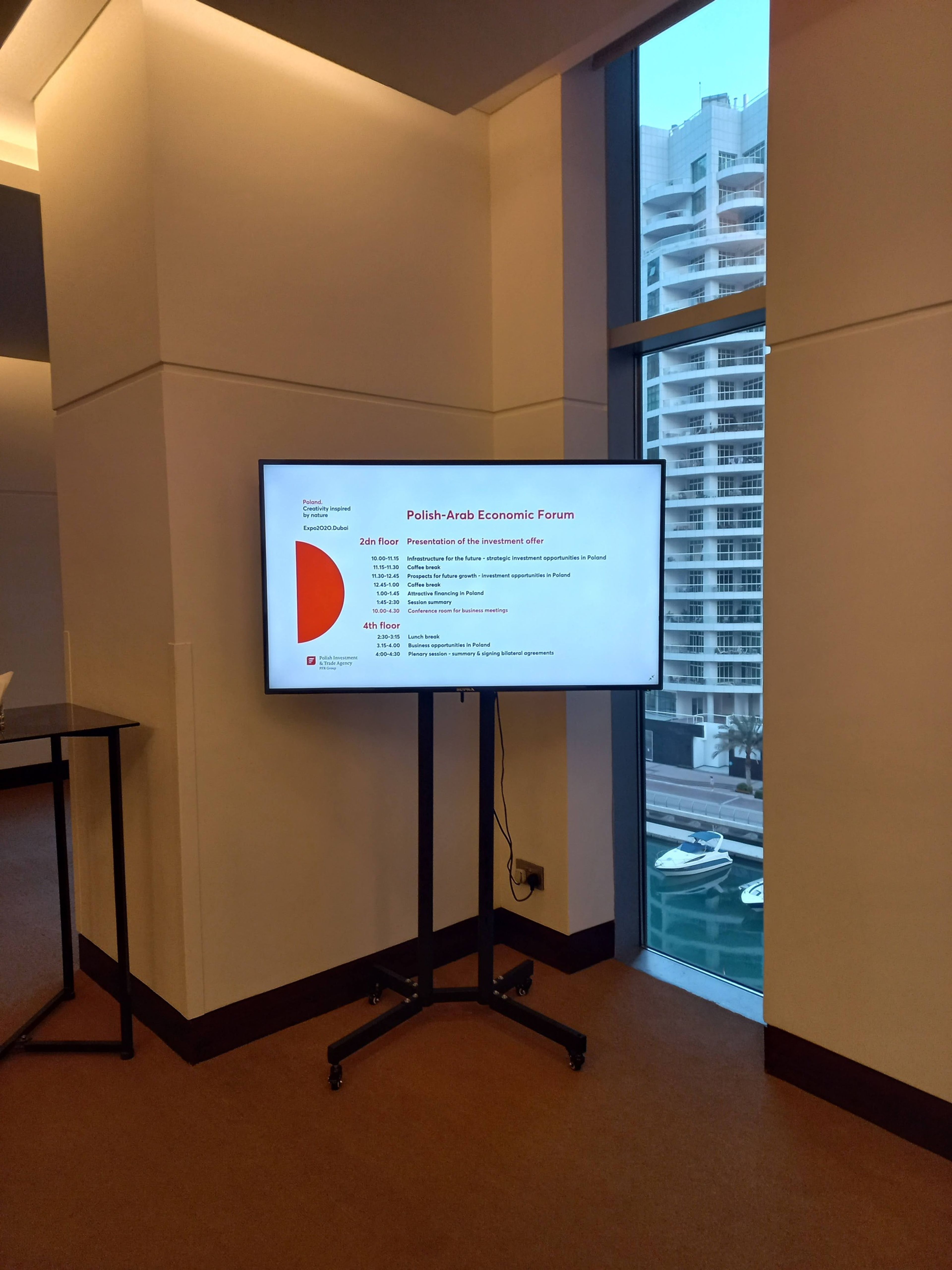 orporate event venue showcasing strategically placed signage at entrances, registration areas, and hallways, guiding a busy crowd of attendees