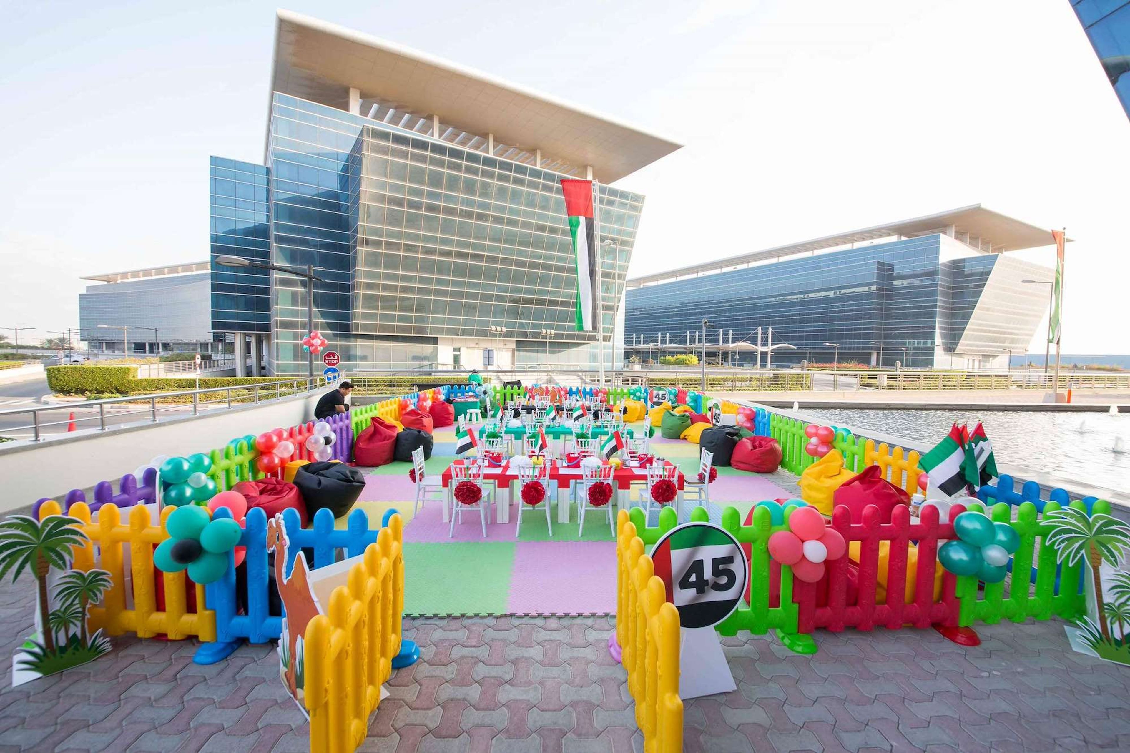 Kids' zone in UAE flag colours with play fences, balloons and activity tables at a National Day celebration