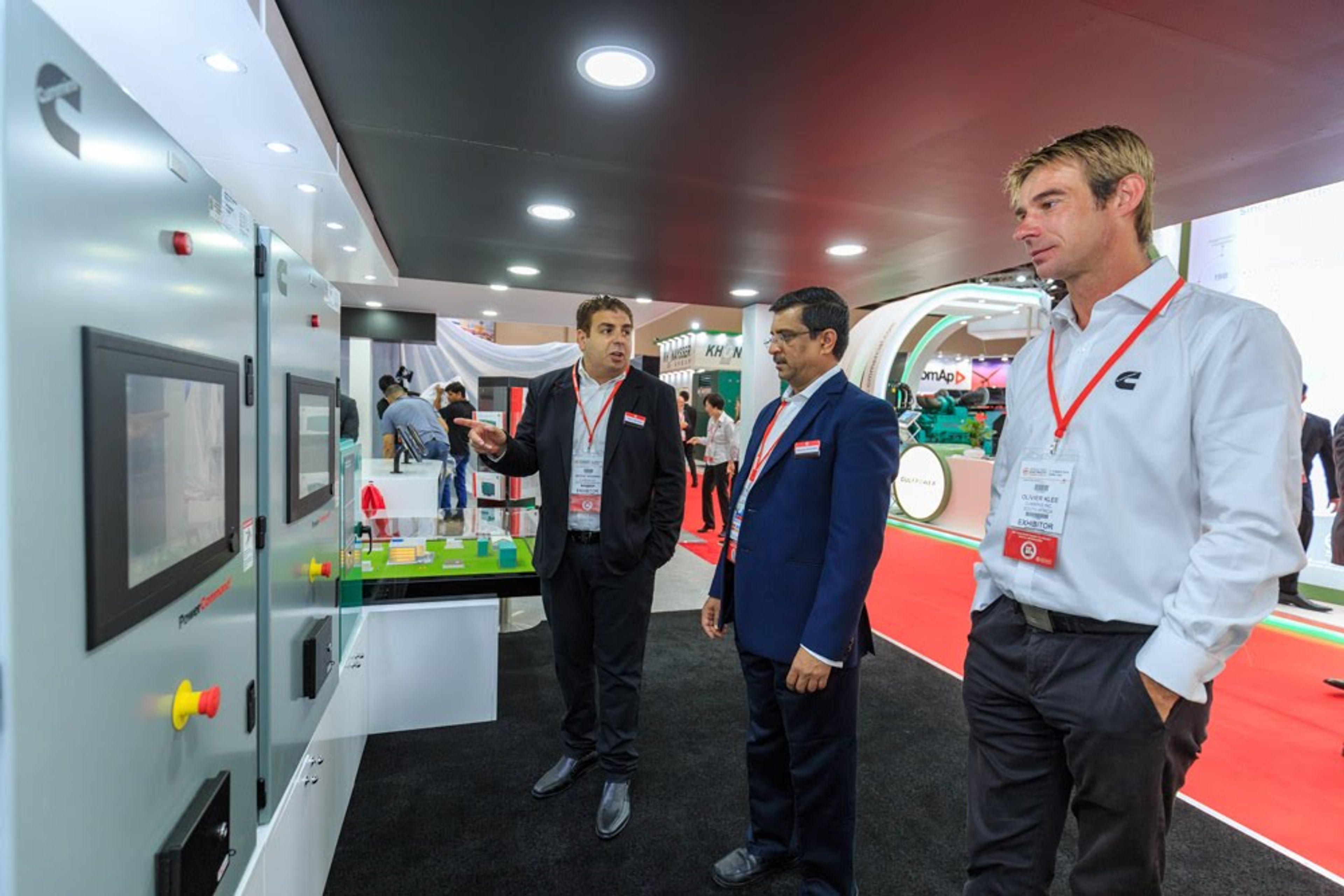 A group of business professionals engaged in a lively discussion at an exhibition, exchanging ideas and networking in a collaborative environment.