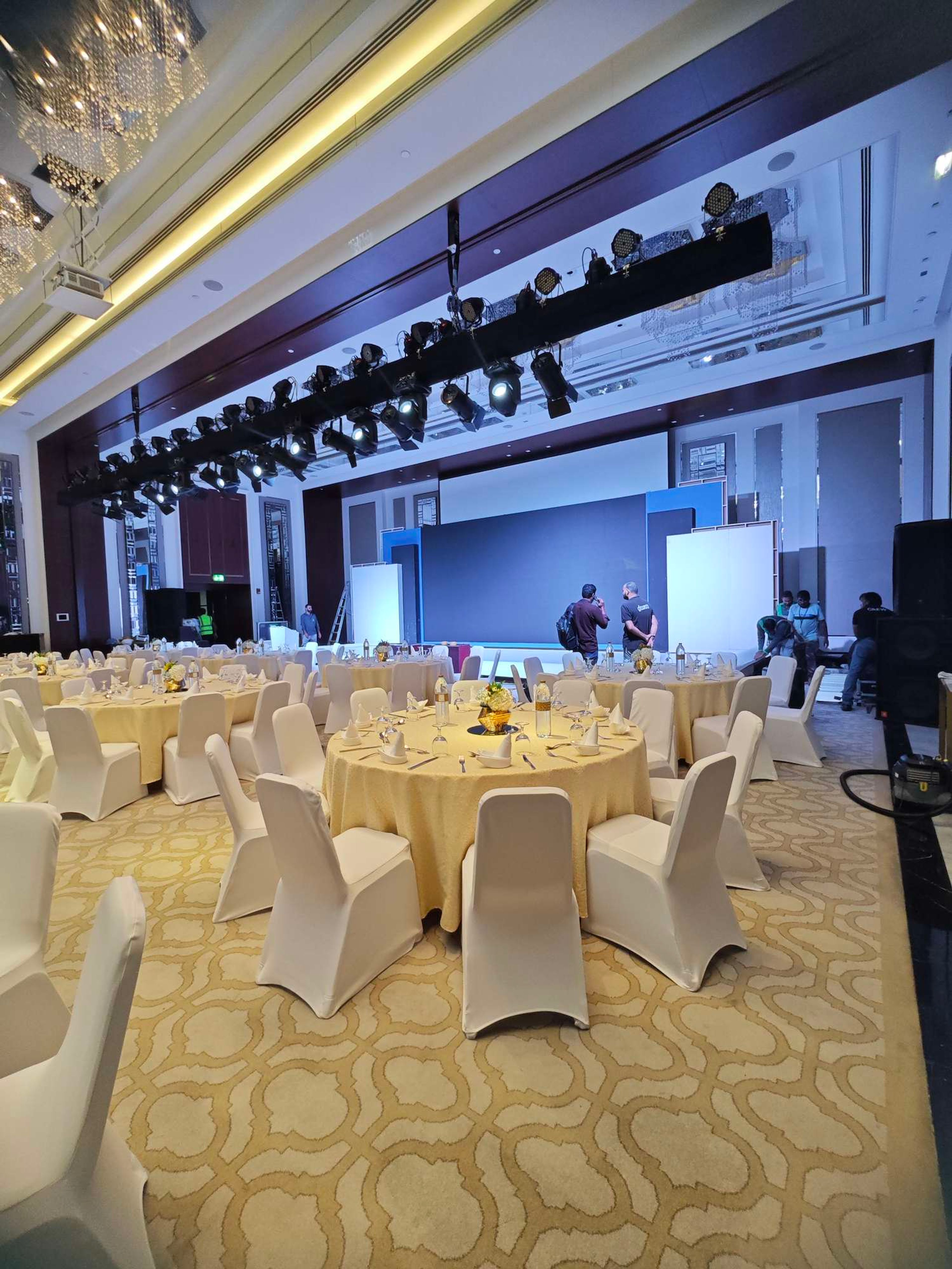 Lighting truss with spotlights and moving heads rigged above a hotel ballroom stage during setup in Dubai
