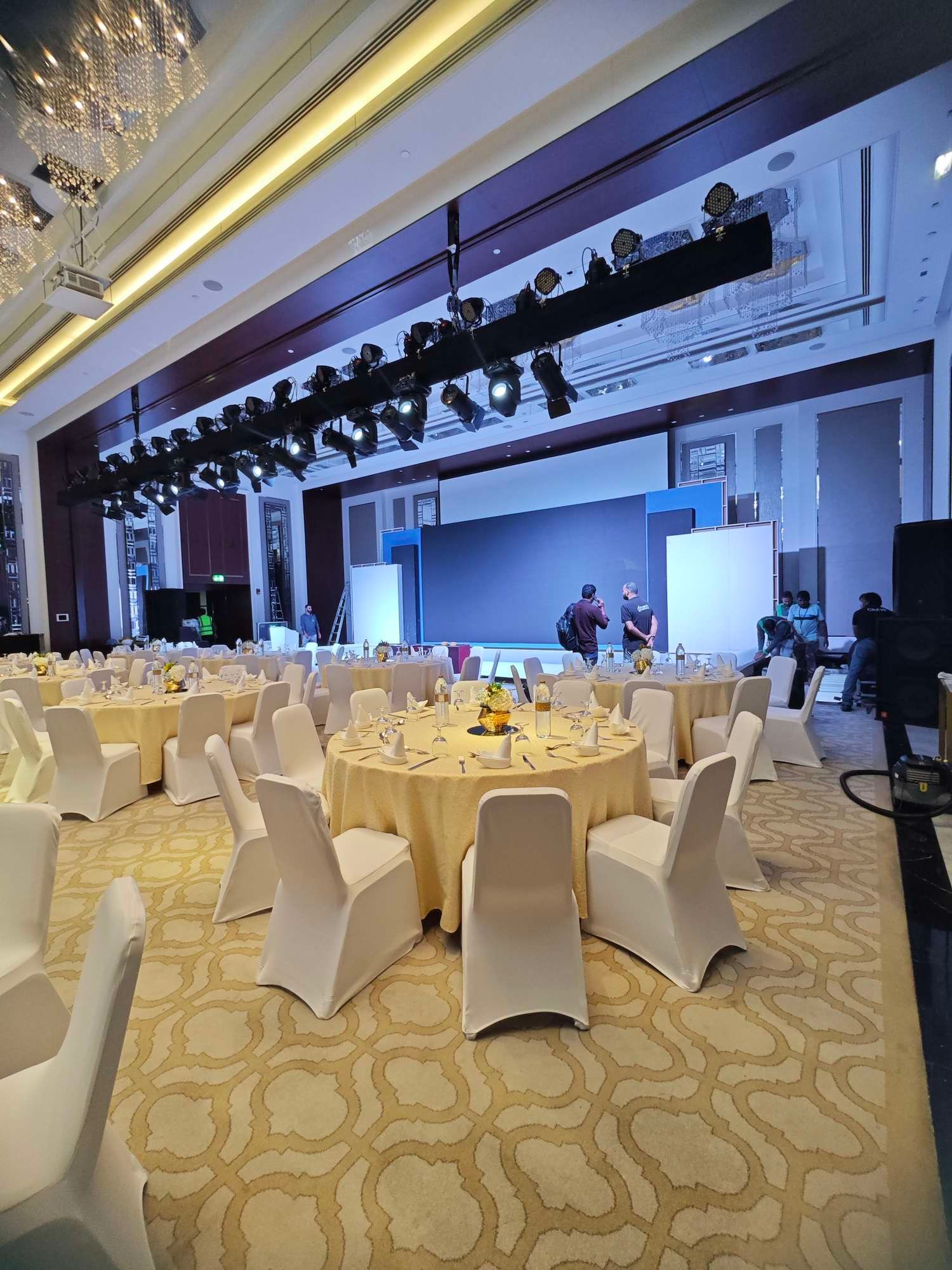 Lighting truss with spotlights and moving heads rigged above a hotel ballroom stage during setup in Dubai