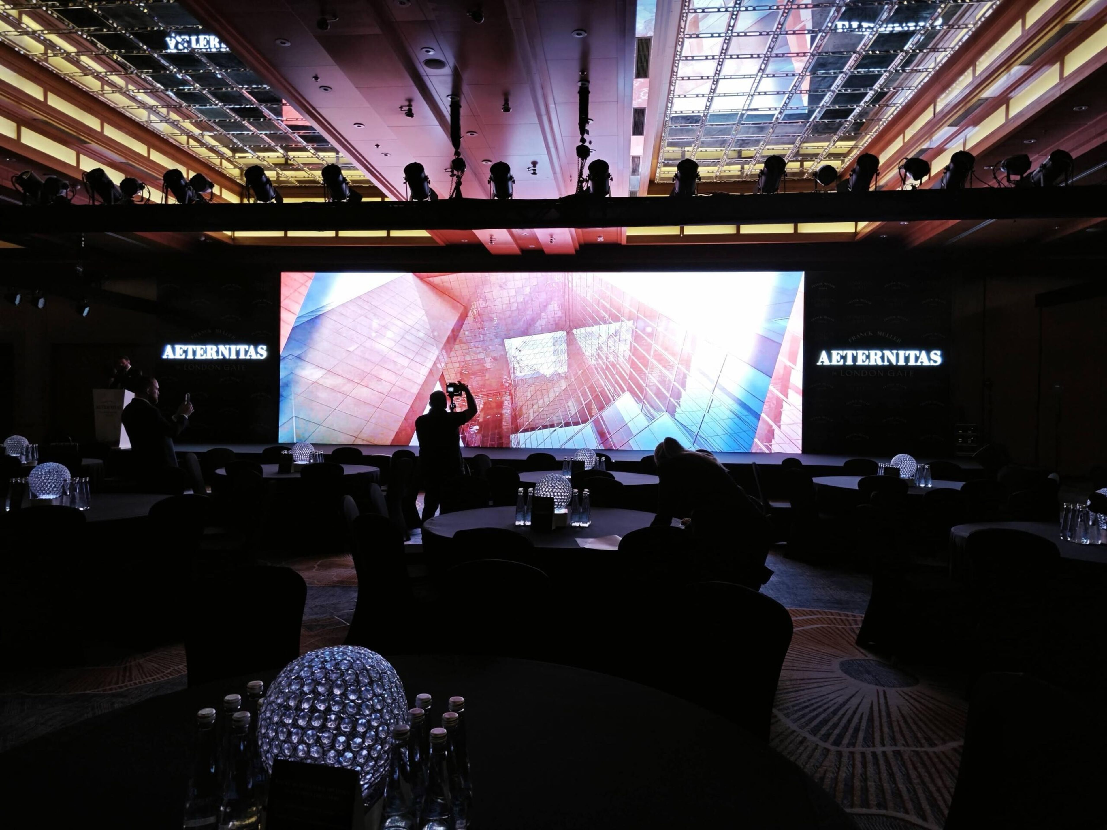 Large LED screen showing visuals to an audience at an evening event