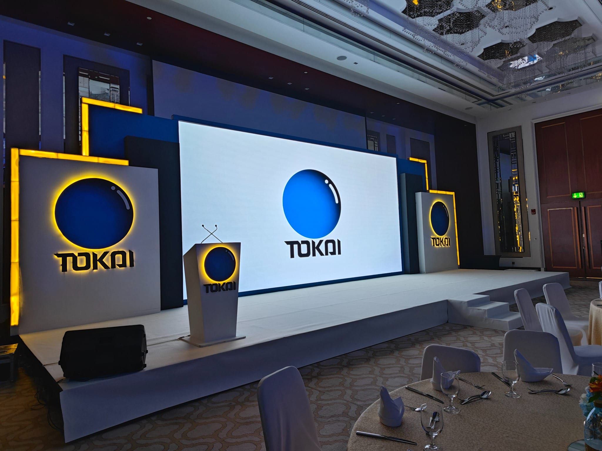 Tokai stage with backlit logo towers and branded lectern