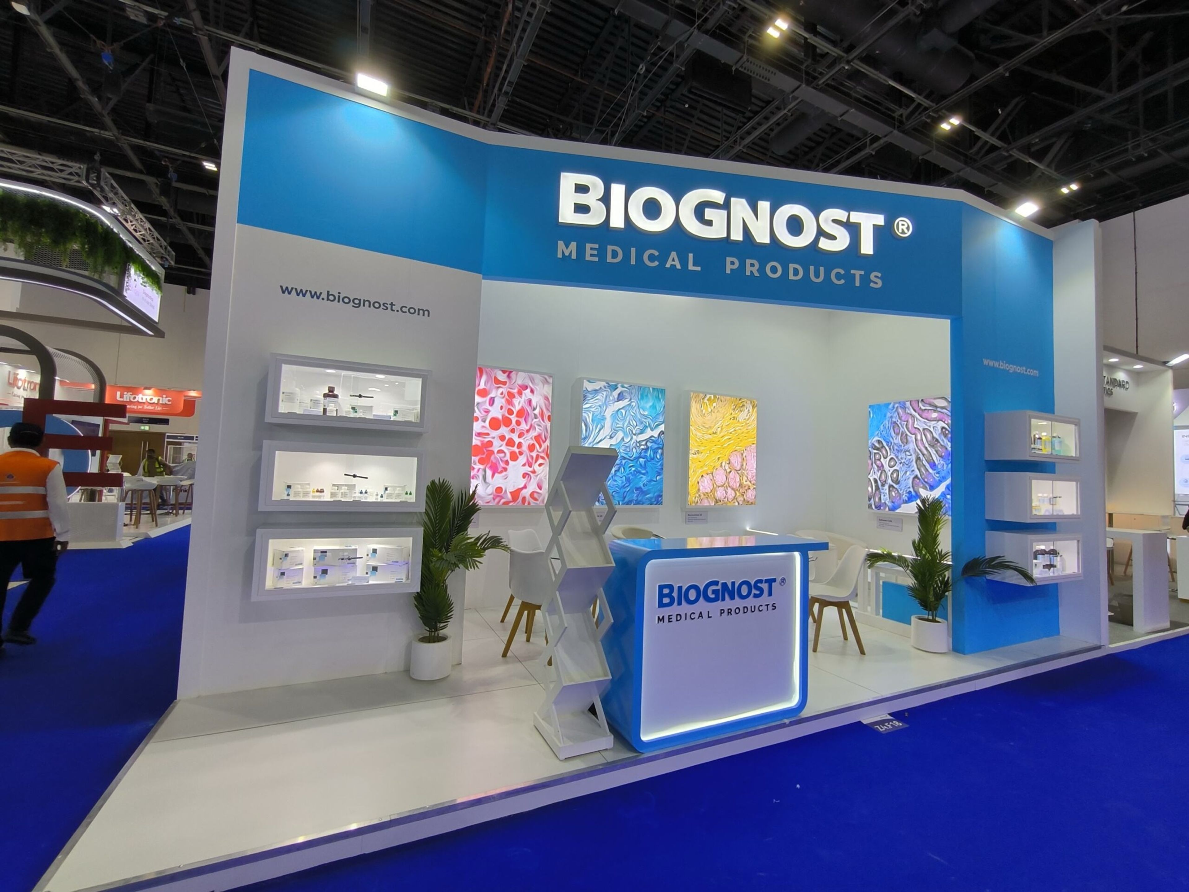 Biognost Medical Products exhibition stand with backlit graphics, display shelves and an illuminated counter, built by Purrple Orryx