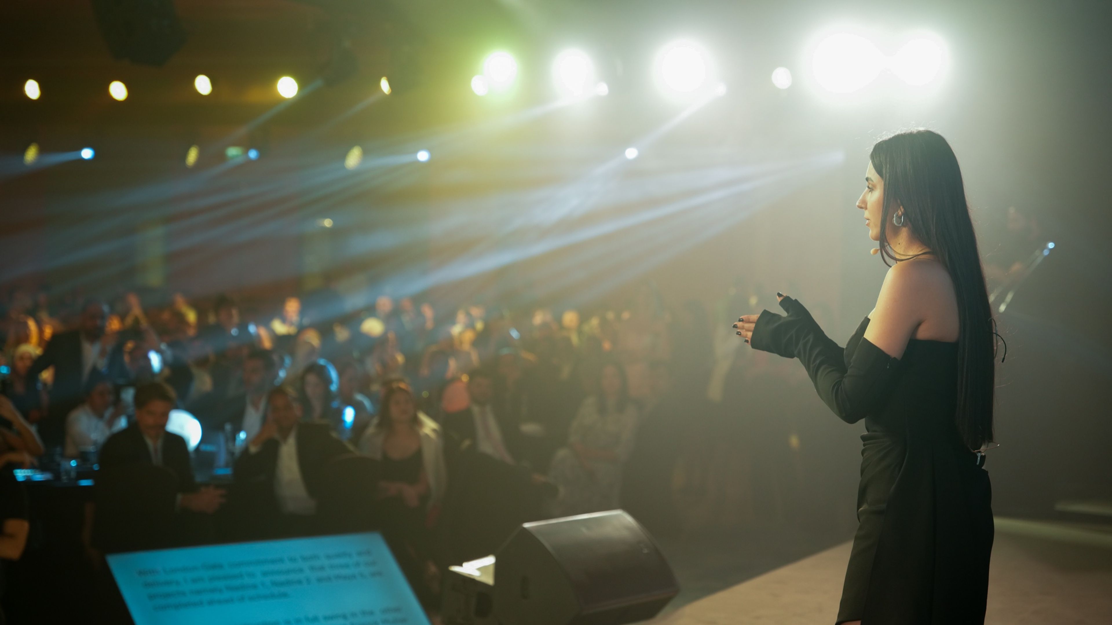 Vanguard CEO delivering a keynote speech from the stage at the launch event, with attentive attendees in the audience, under ambient lighting
