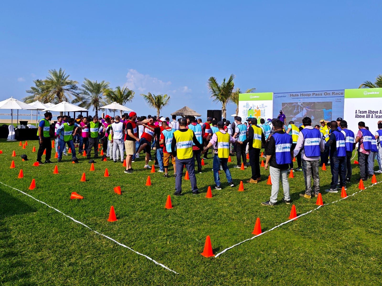 Staff lined up in team vests on the lawn for the Peikko Gulf team building day at Hilton Ras Al Khaimah