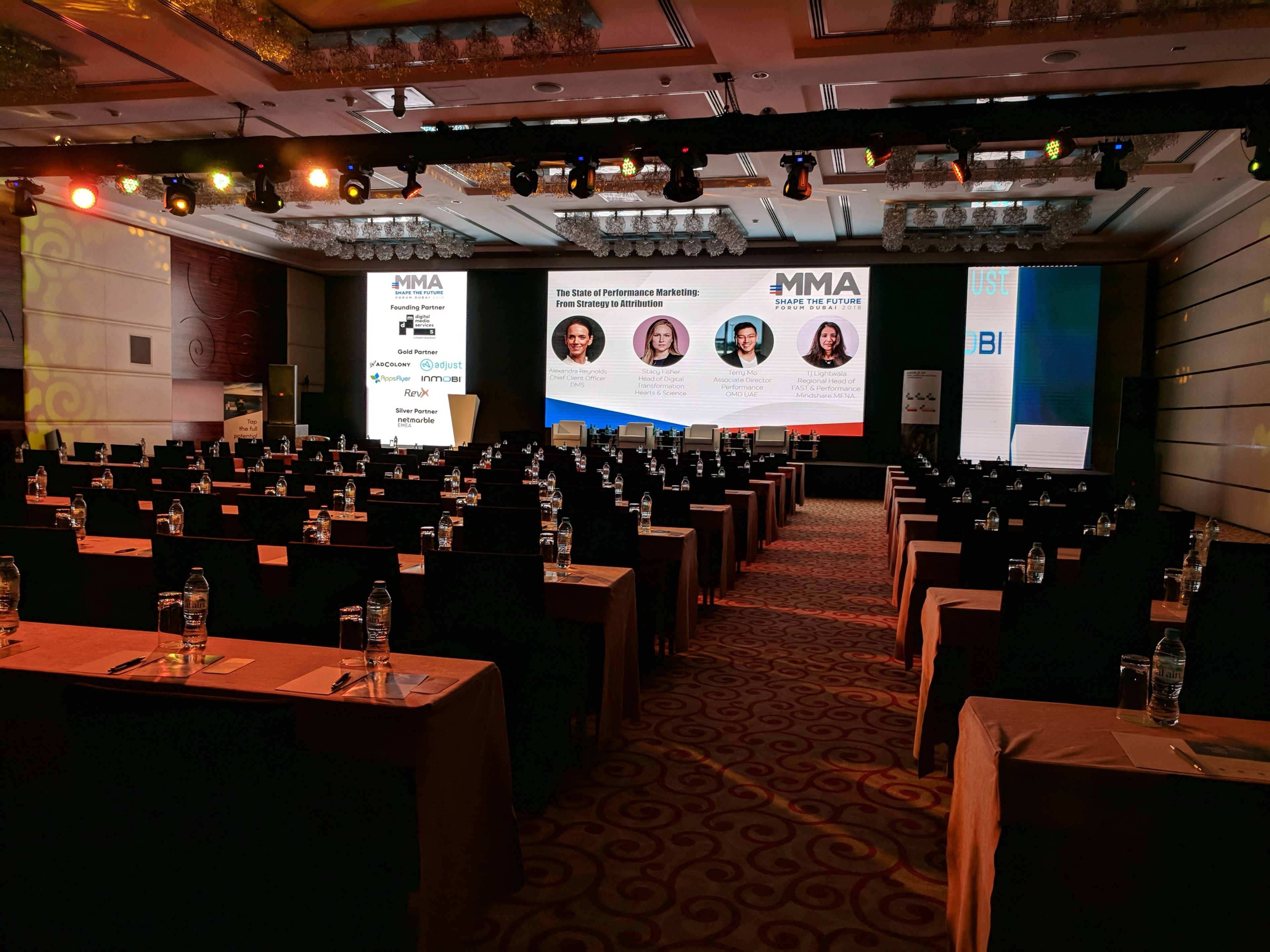 Hotel ballroom in Dubai set for a corporate conference, with a wide LED screen stage, side screens and an overhead lighting rig