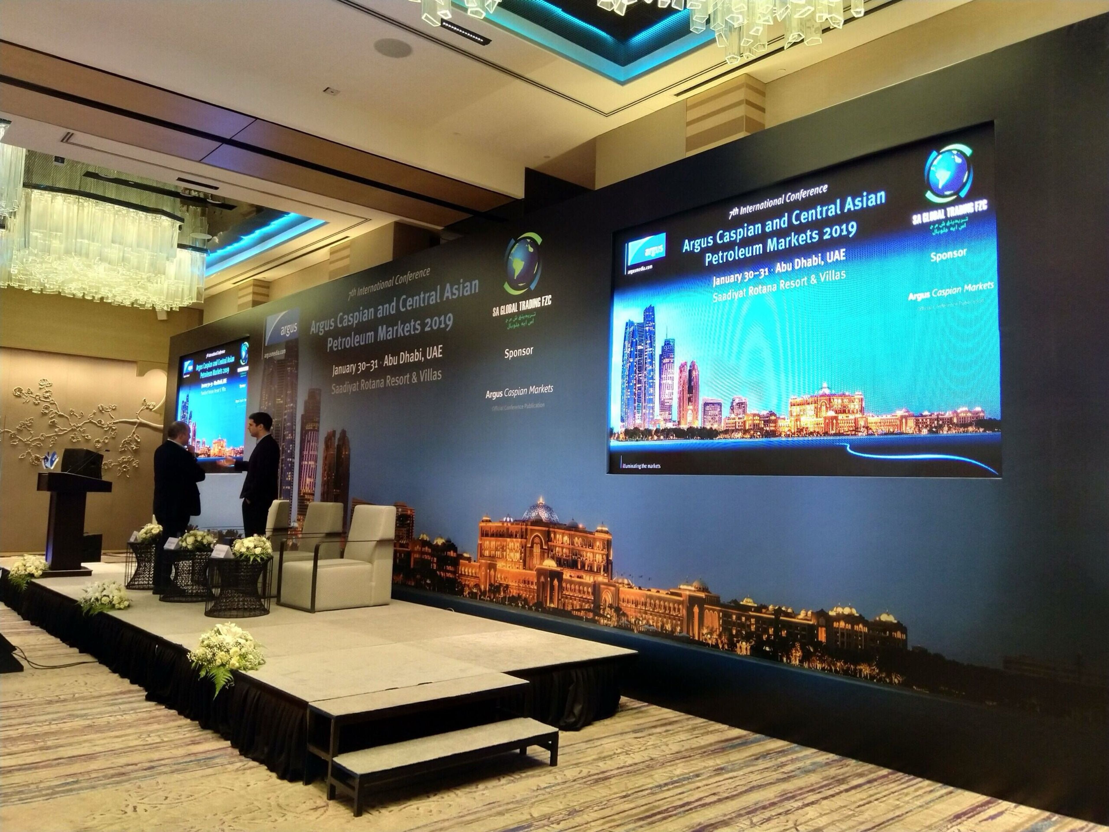 Corporate conference stage with LED screens and a city-skyline backdrop