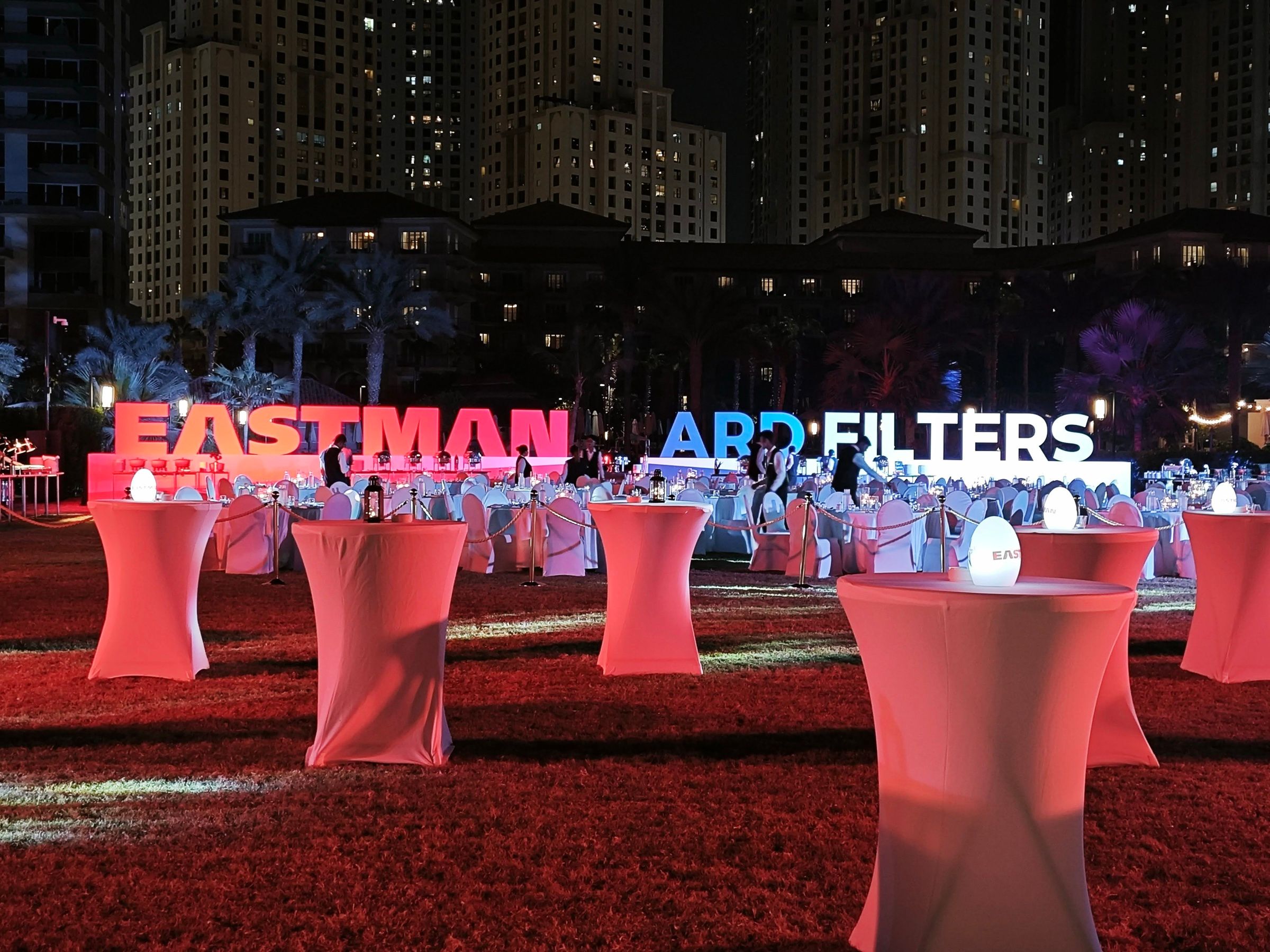 Outdoor evening event with branded letters and cocktail tables