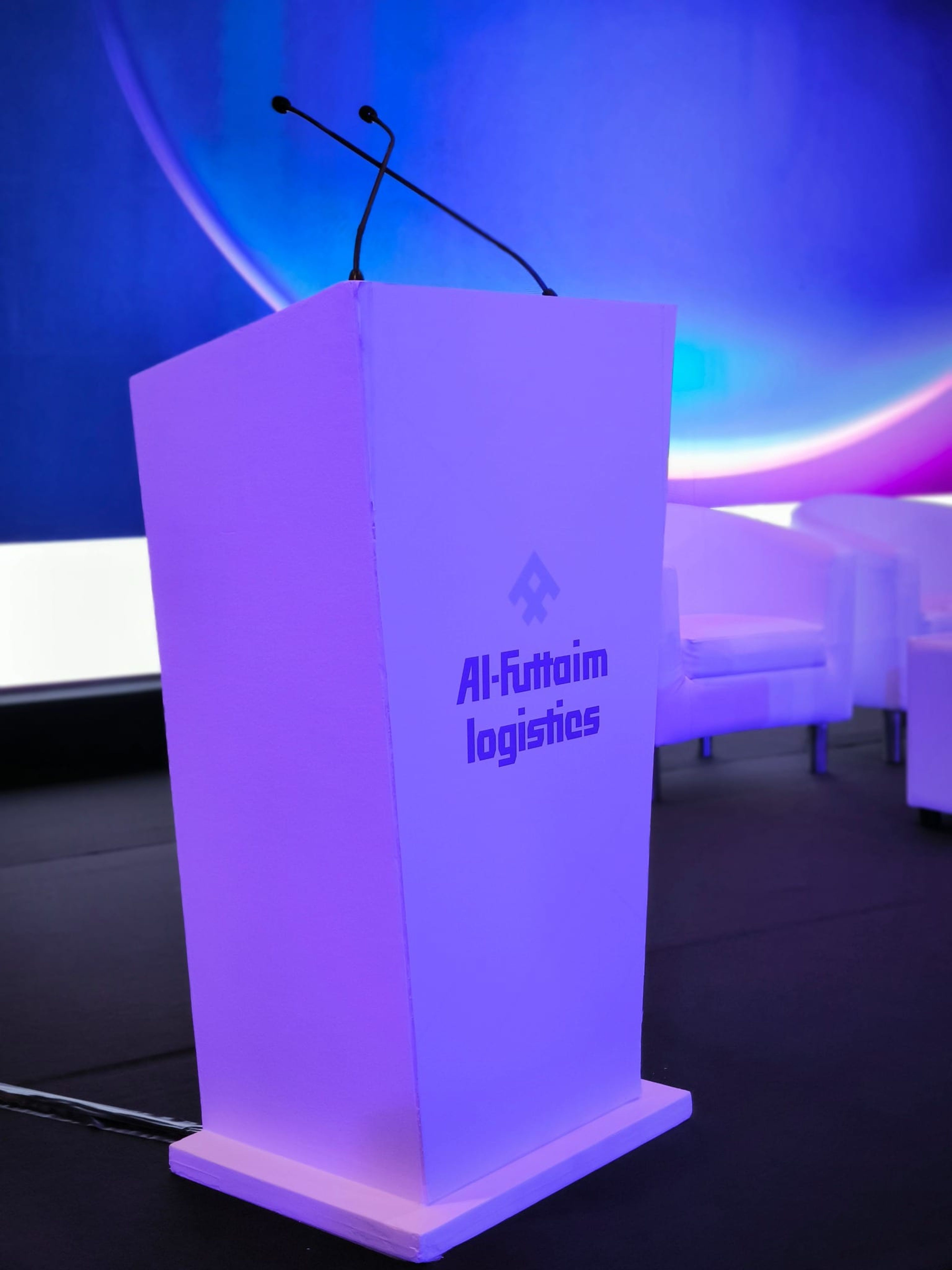 Al-Futtaim Logistics branded lectern on stage under blue lighting