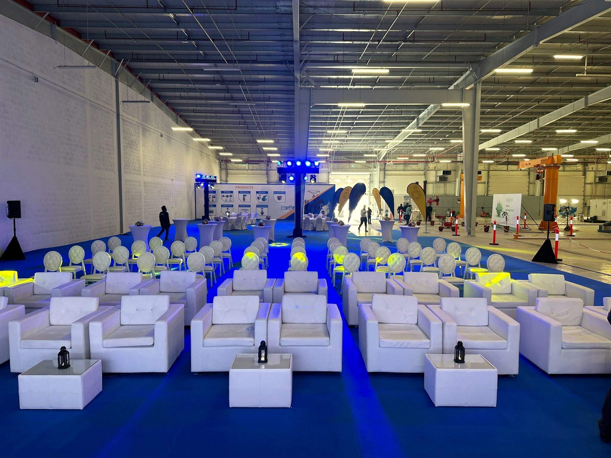 White lounge seating and a central aisle facing the stage inside the MT Group manufacturing unit launch, Abu Dhabi