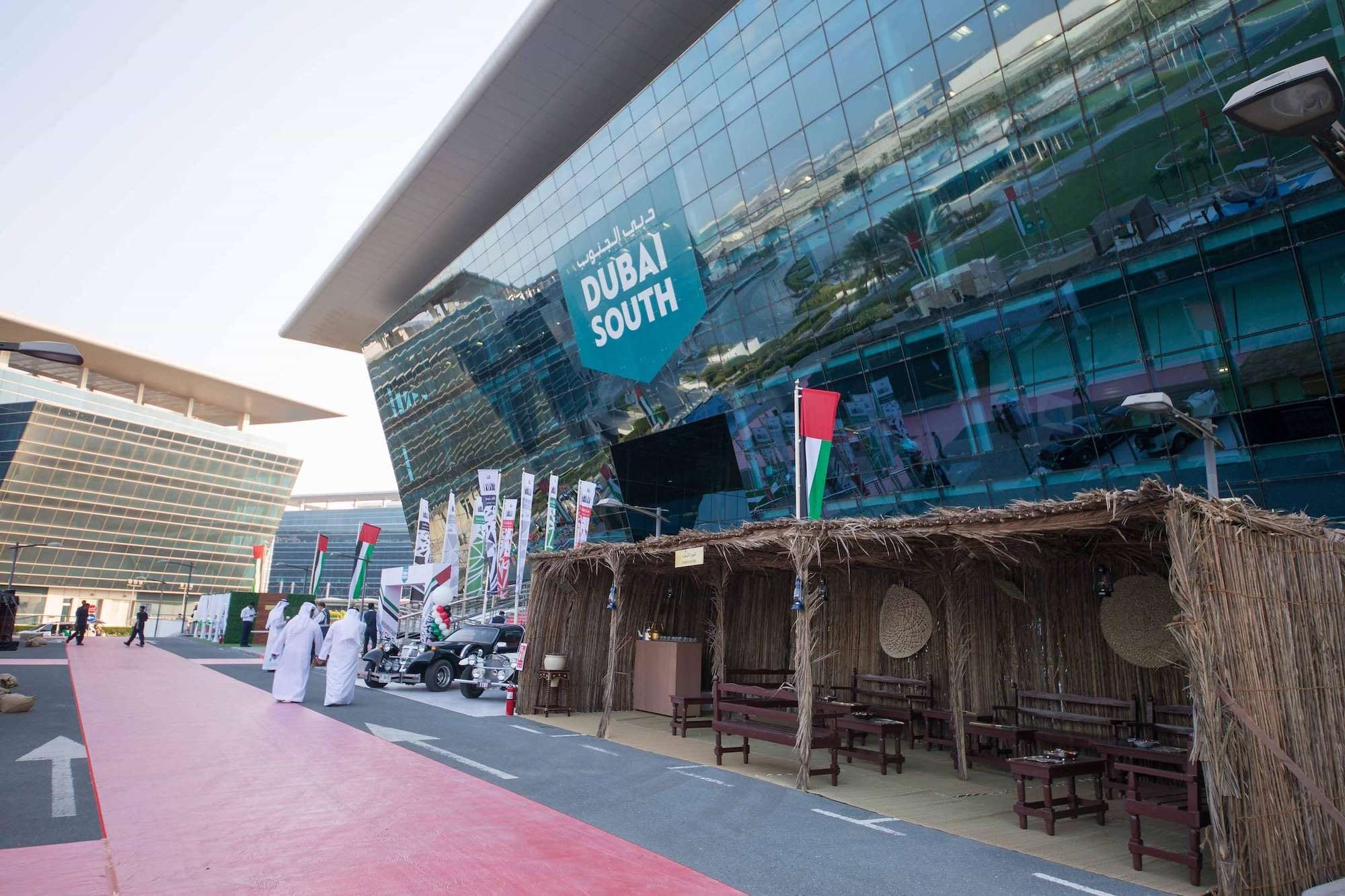 Guests walking past palm frond heritage stalls at a corporate UAE National Day celebration in Dubai