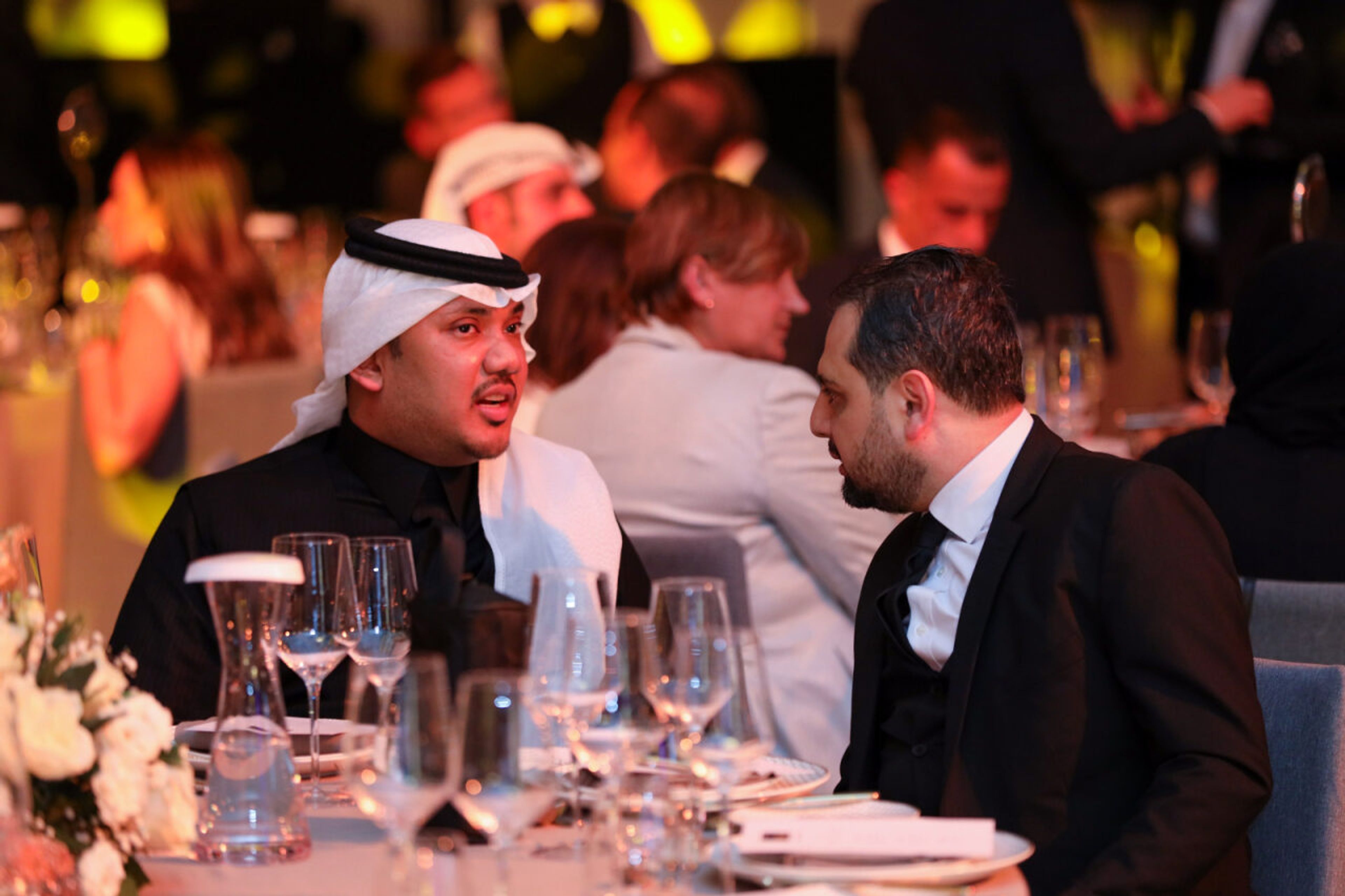 Guests chatting at a dinner table during a corporate gala