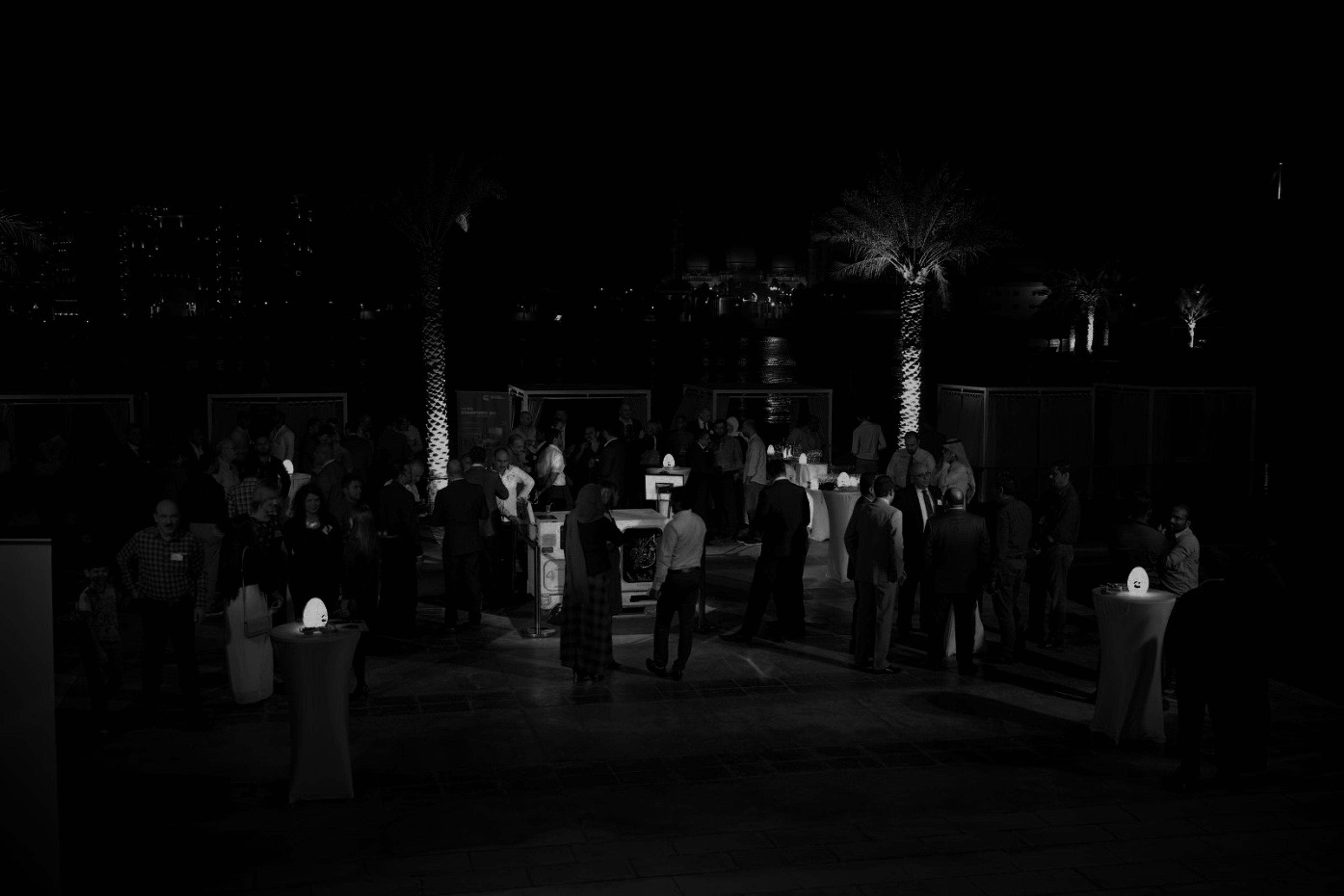 Guests exploring branded experience booths at an evening outdoor event in Dubai