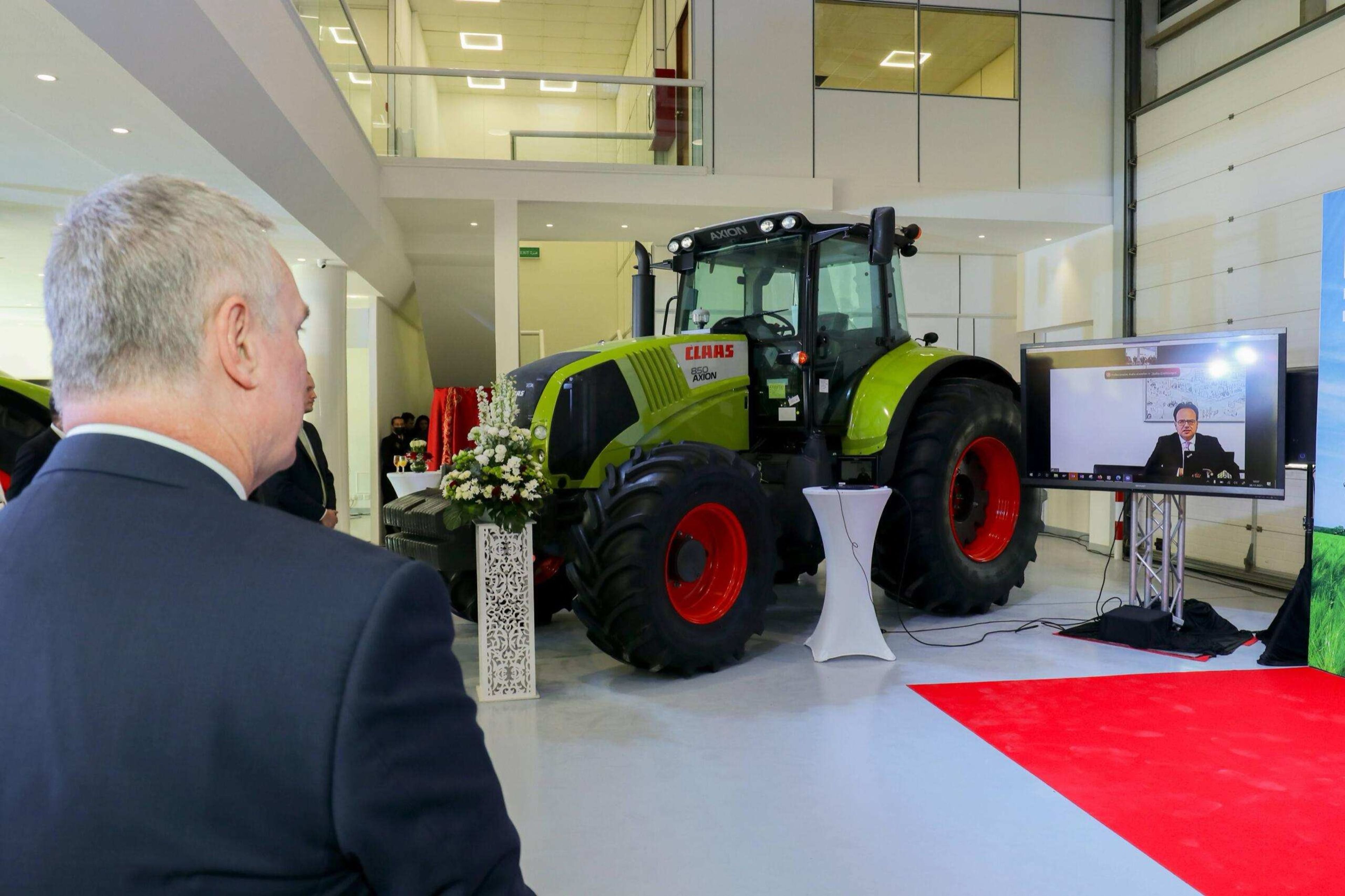 Visitor viewing a tractor displayed at an agricultural exhibition stand