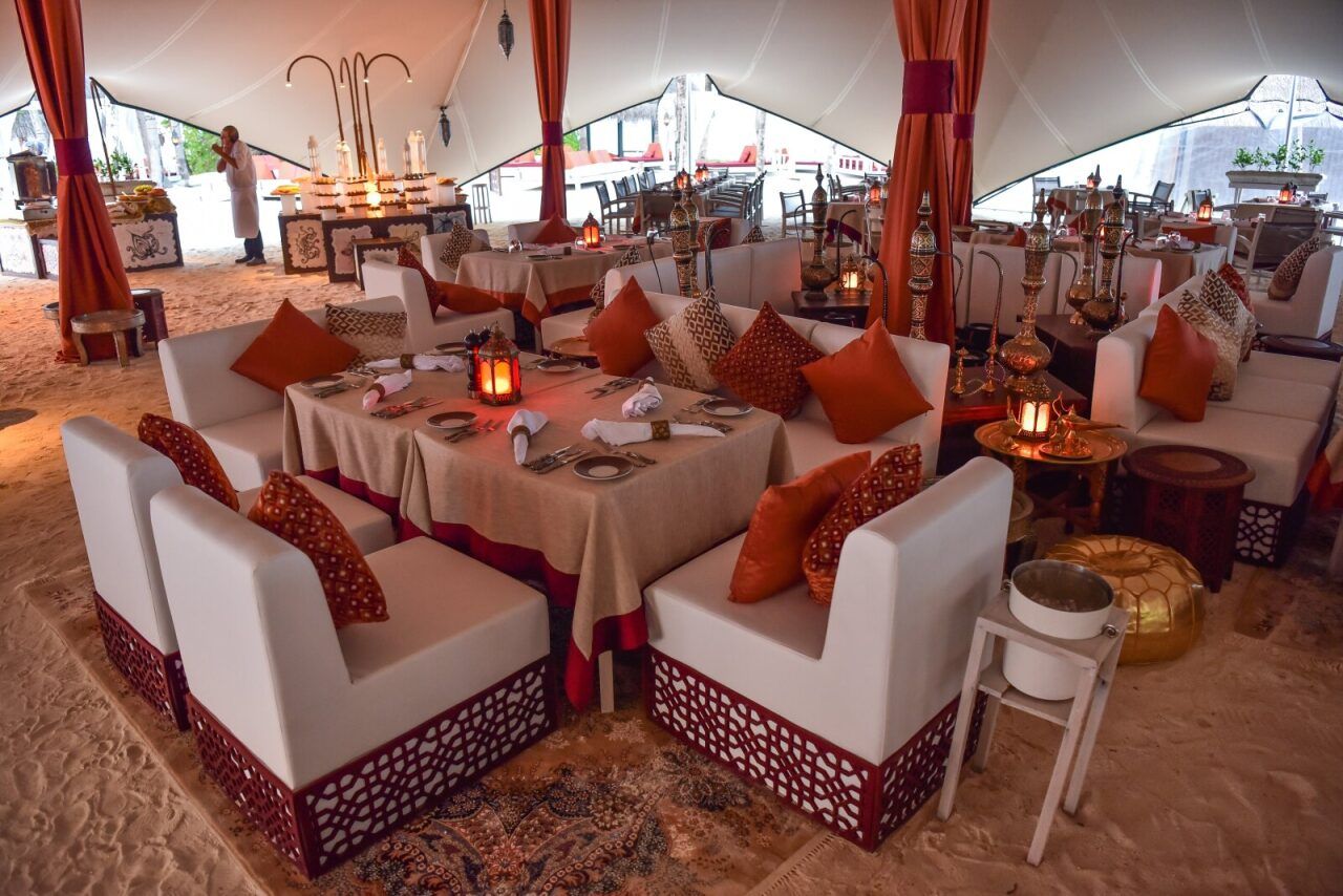 Outdoor lounge area with white sofas and cushions for an evening event