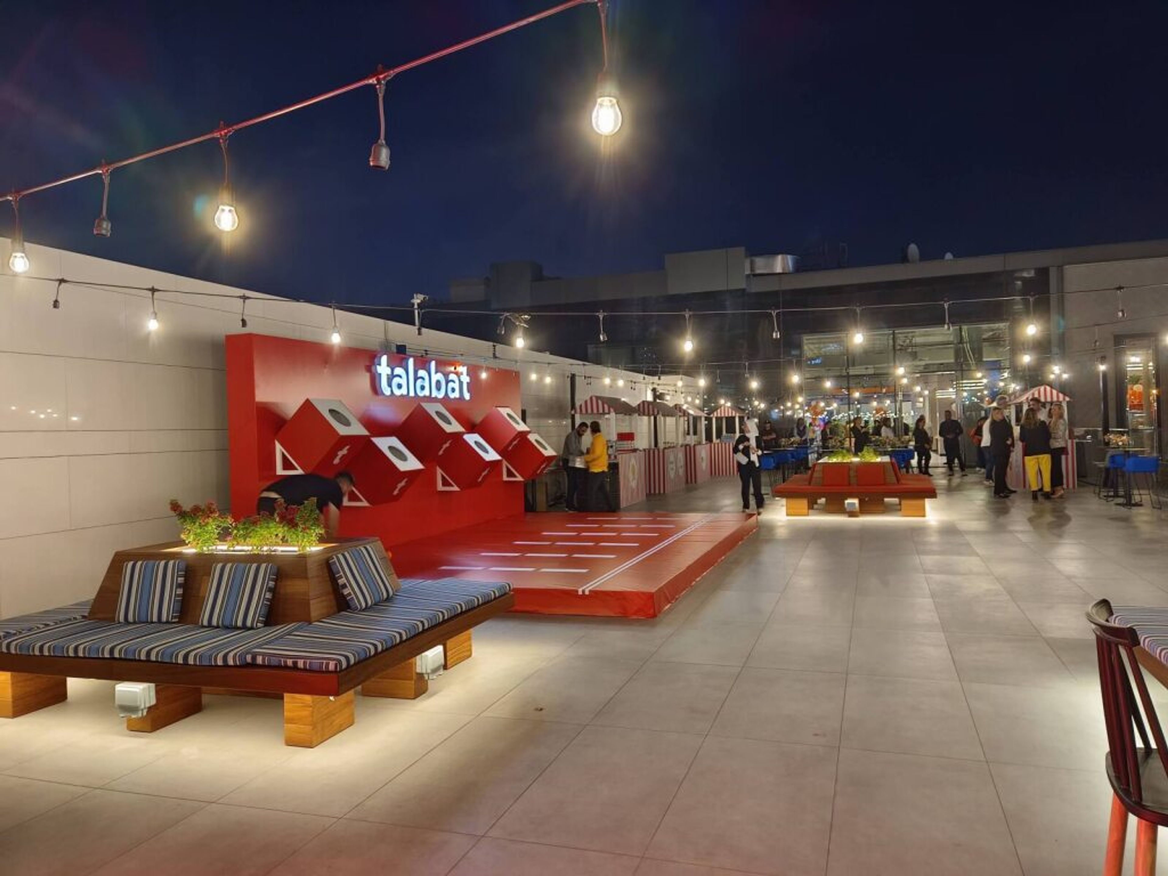 Outdoor exhibition pavilion with red furniture at night