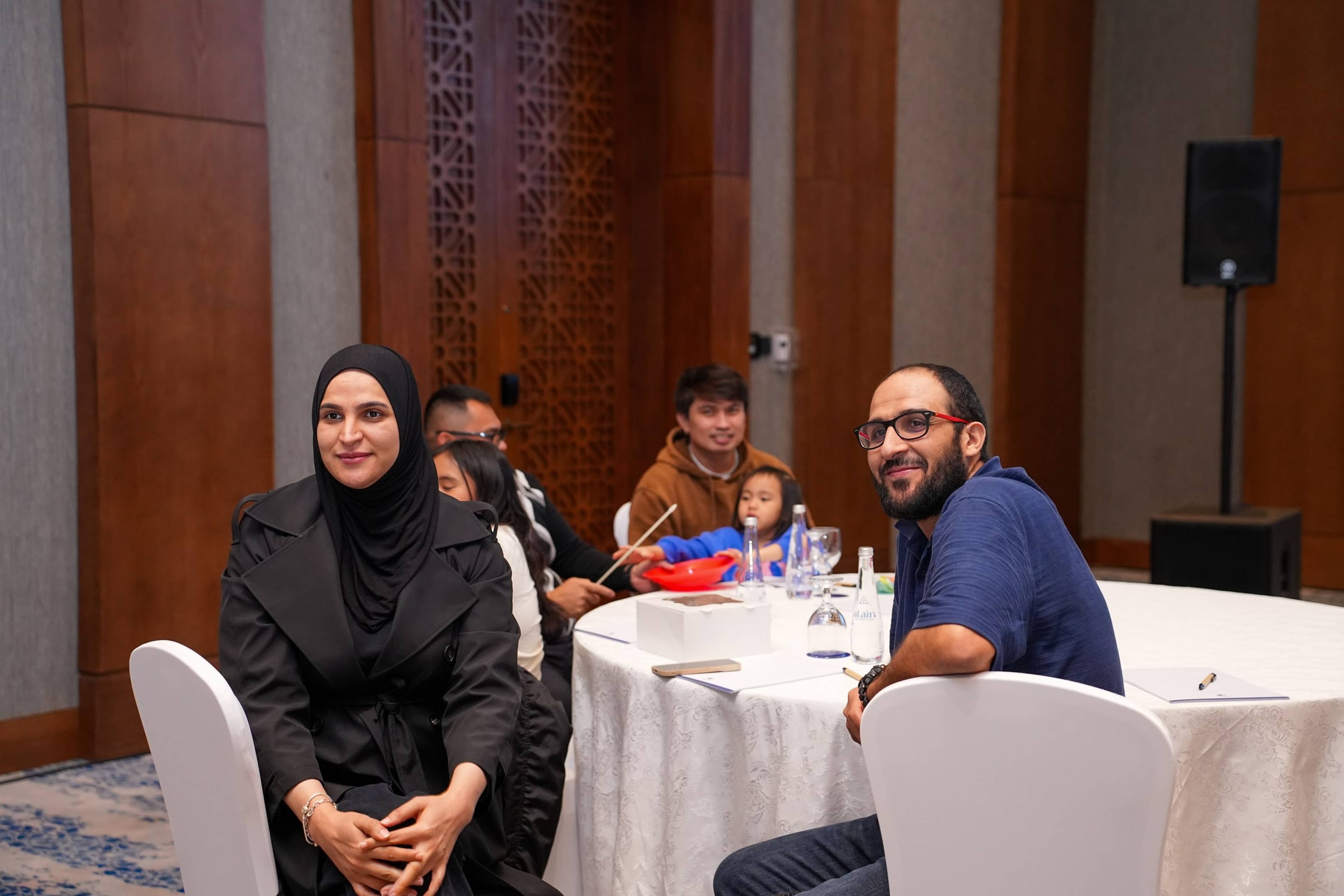 Families gathered at a table during a company family day by the beach in Dubai