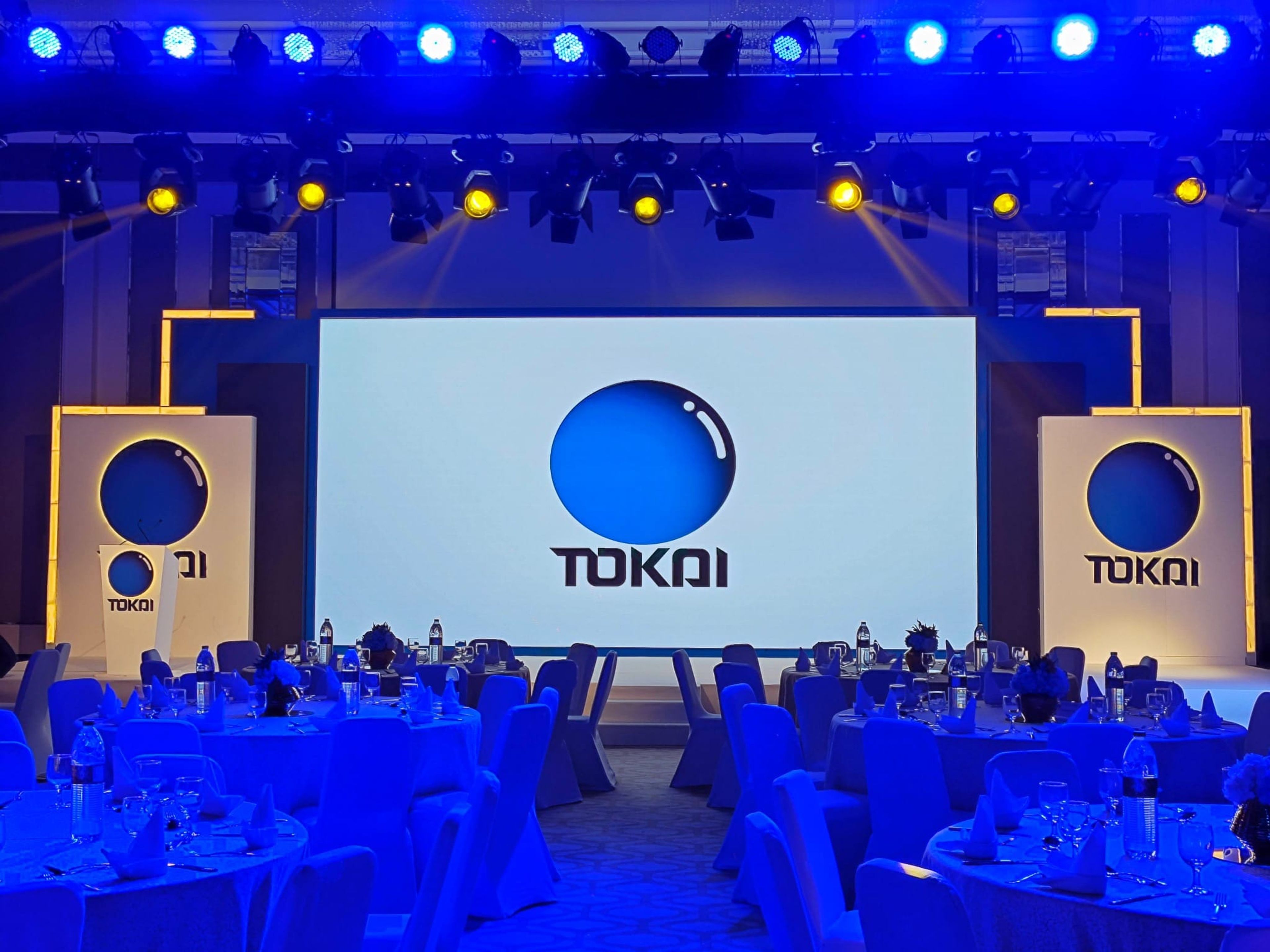 Tokai branded stage with LED screen and blue uplighting over the gala tables