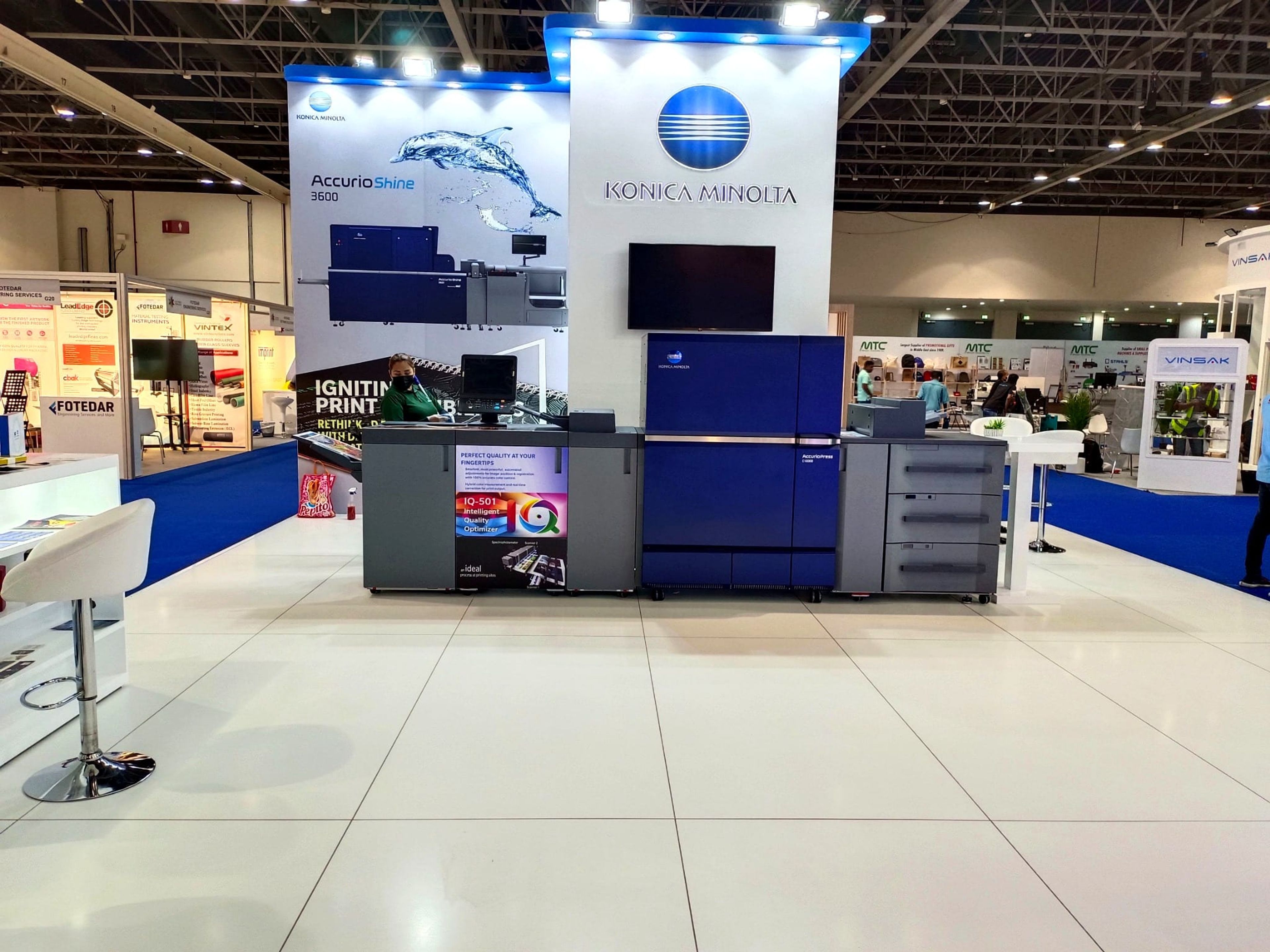 Konica Minolta exhibition stand with a printer display counter at a Dubai trade show
