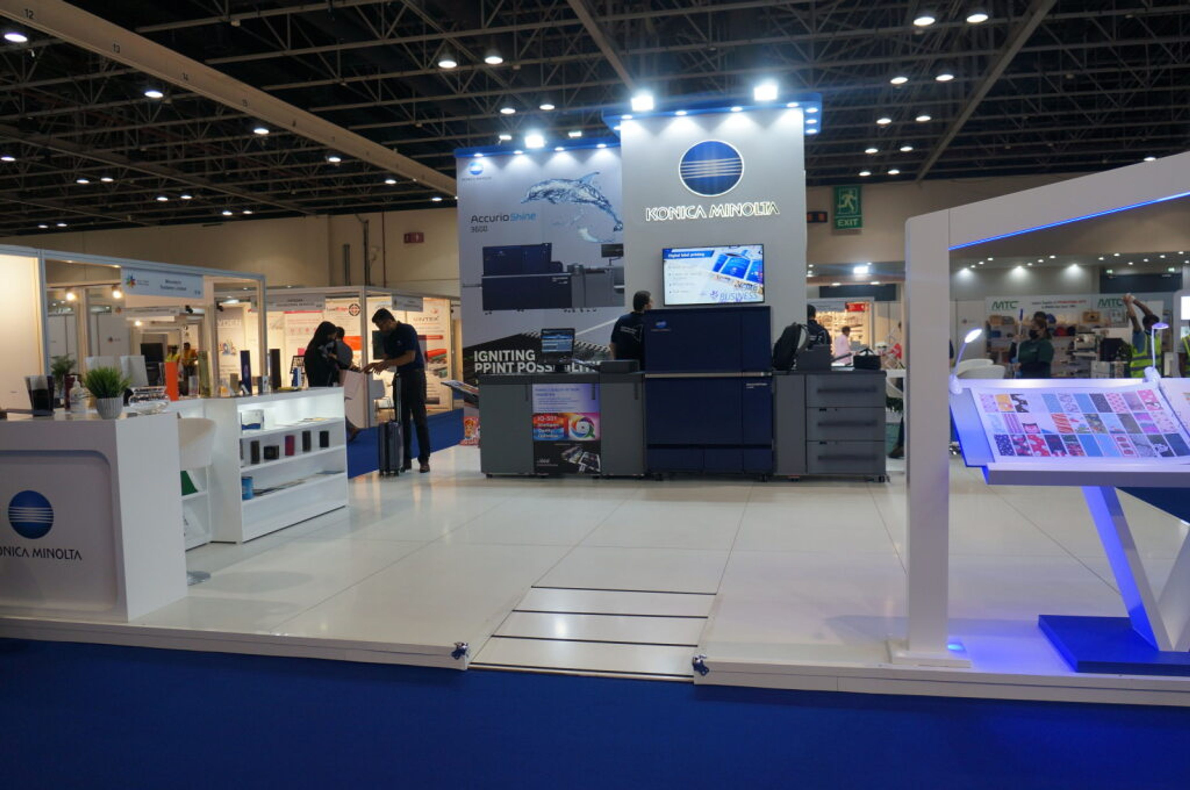 White exhibition stand with screens and product displays