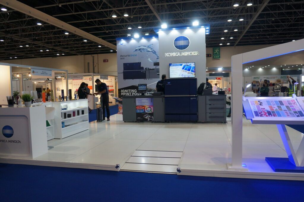 White exhibition stand with screens and product displays