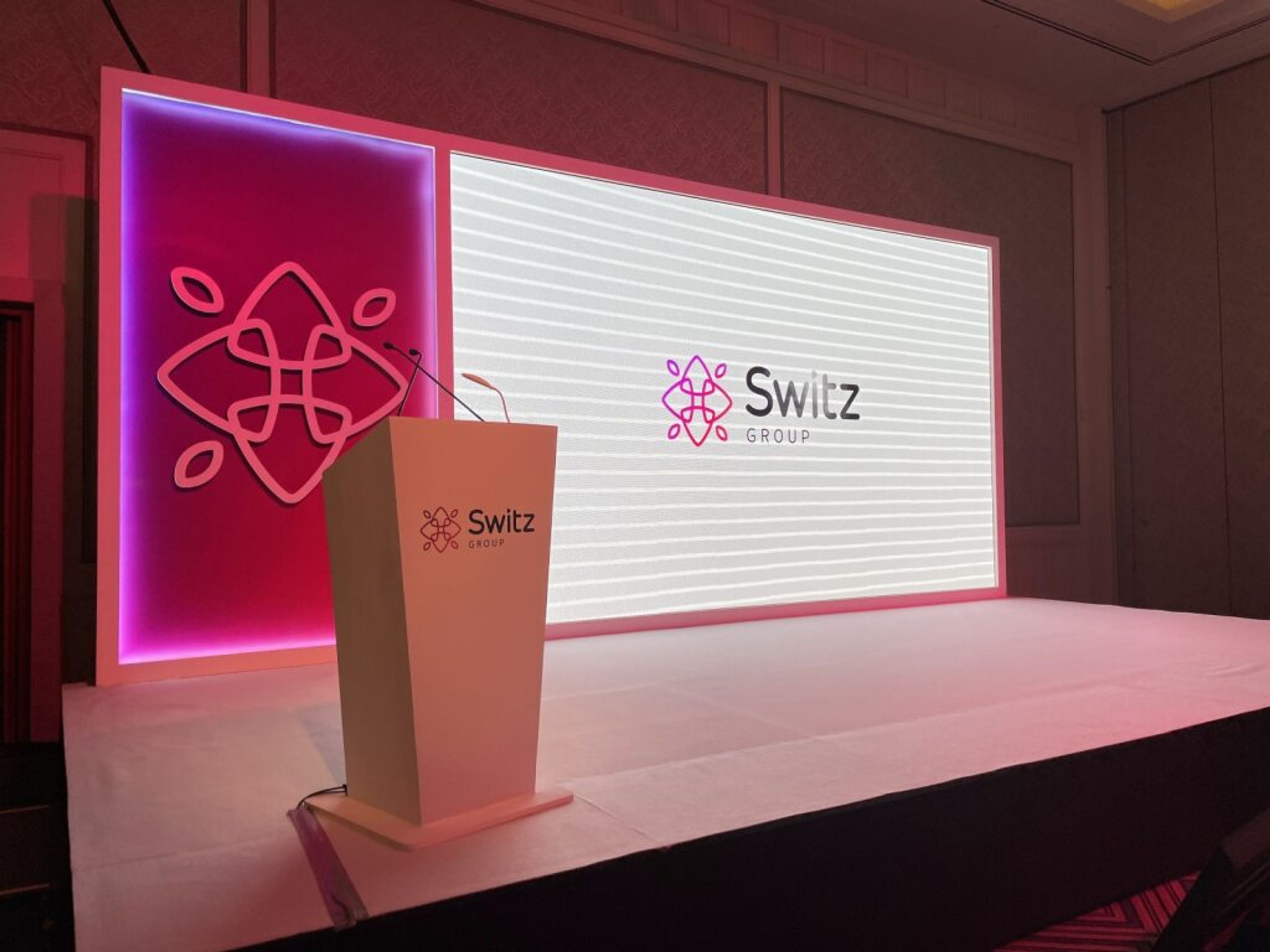 Minimal stage with a podium and illuminated brand logo screen