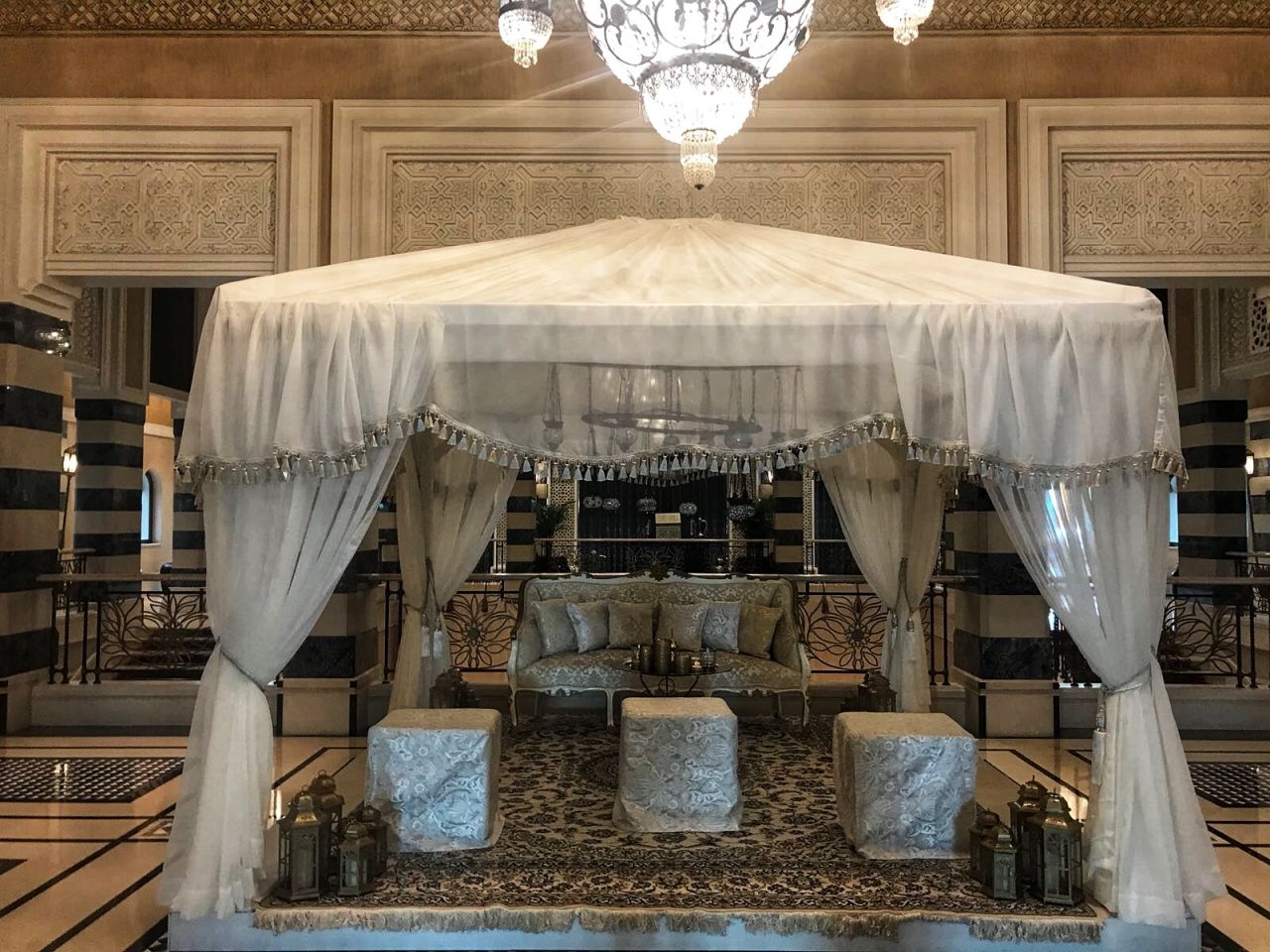 White draped canopy lounge with cushions in an event hall