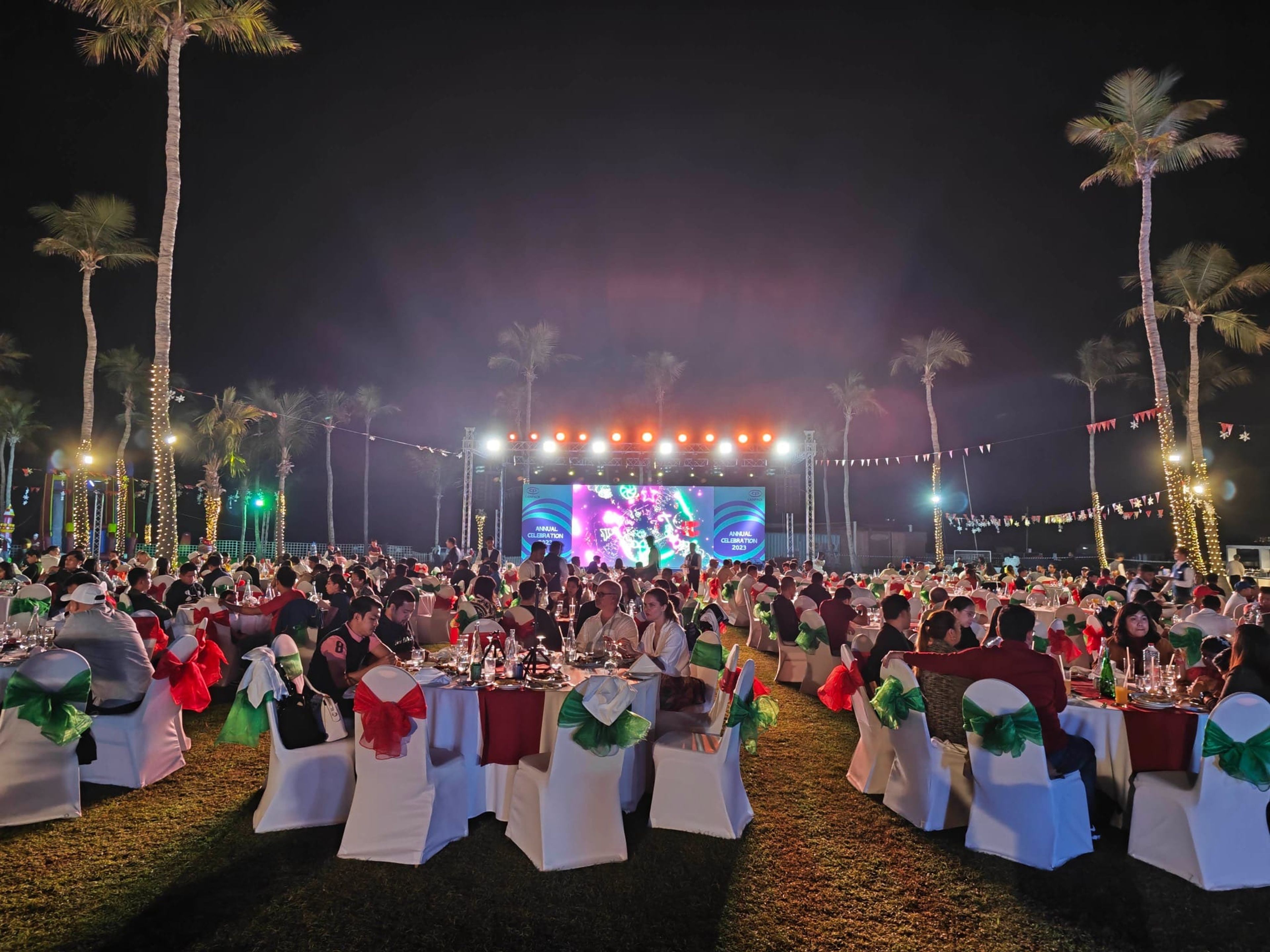 Evening view of guest tables and the lit stage at the CANPACK family day