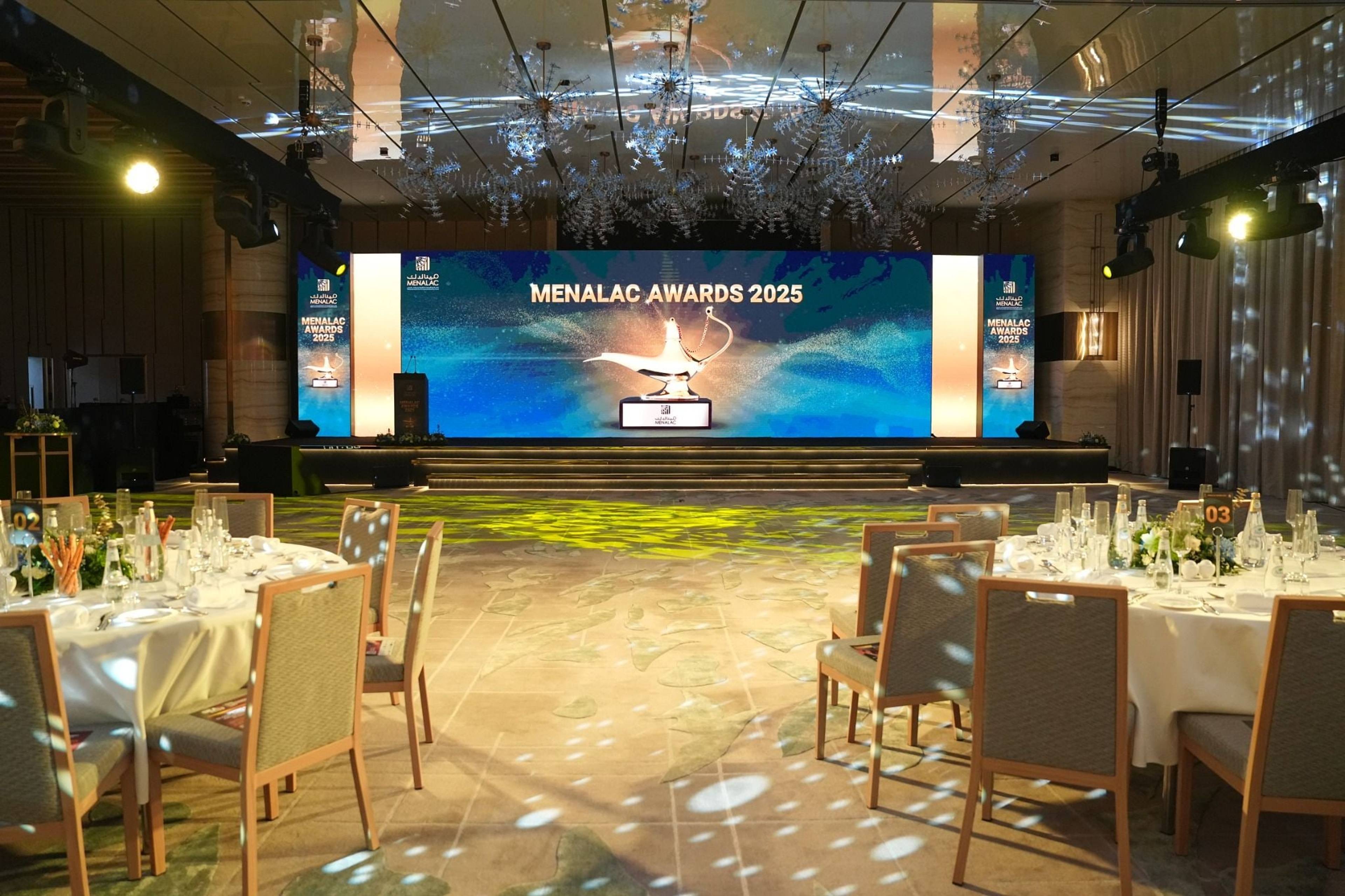 MENALAC Awards 2025 stage and banquet tables under suspended lighting and patterned floor projections