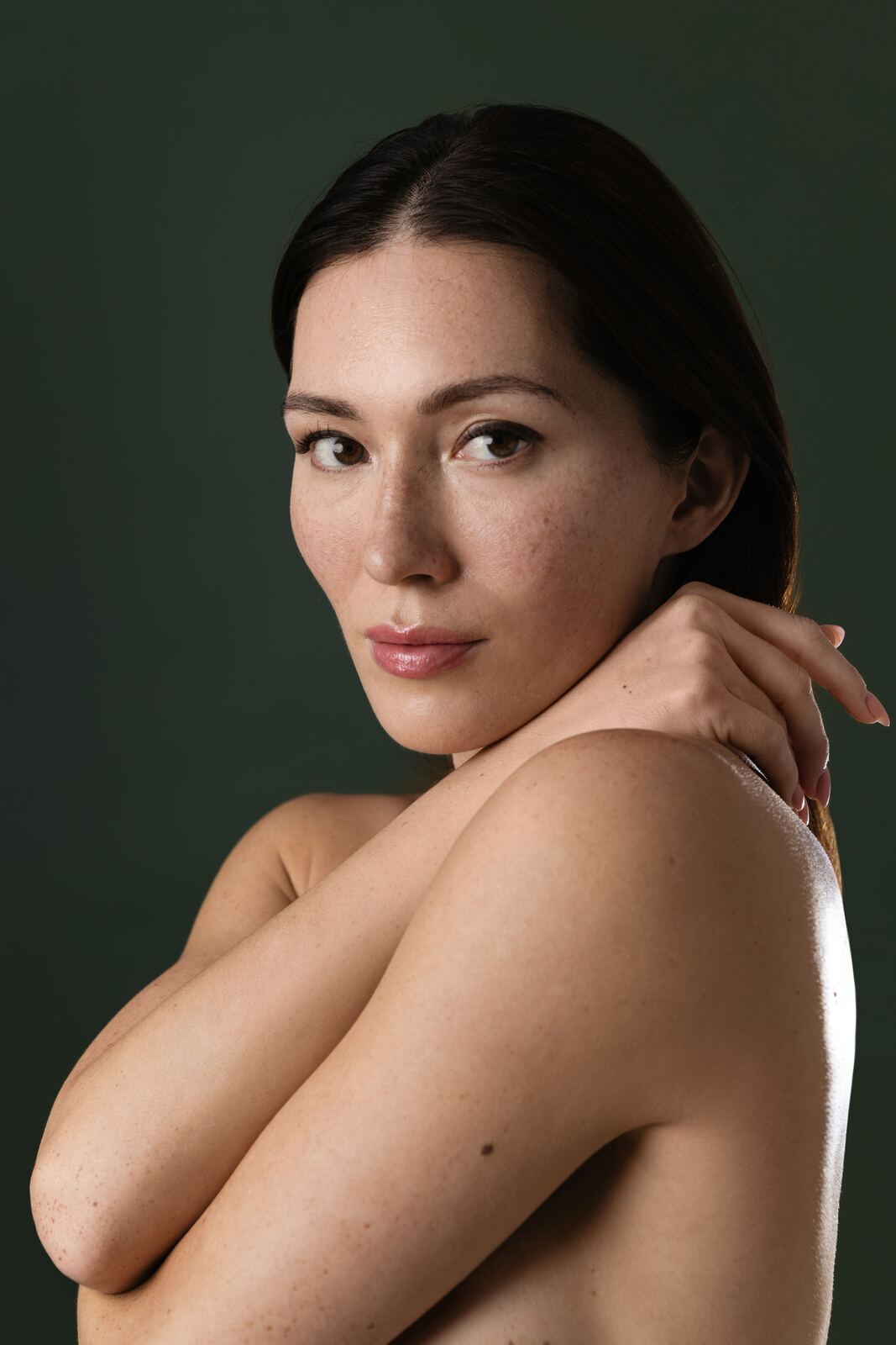 Calm portrait of a woman against a deep green backdrop