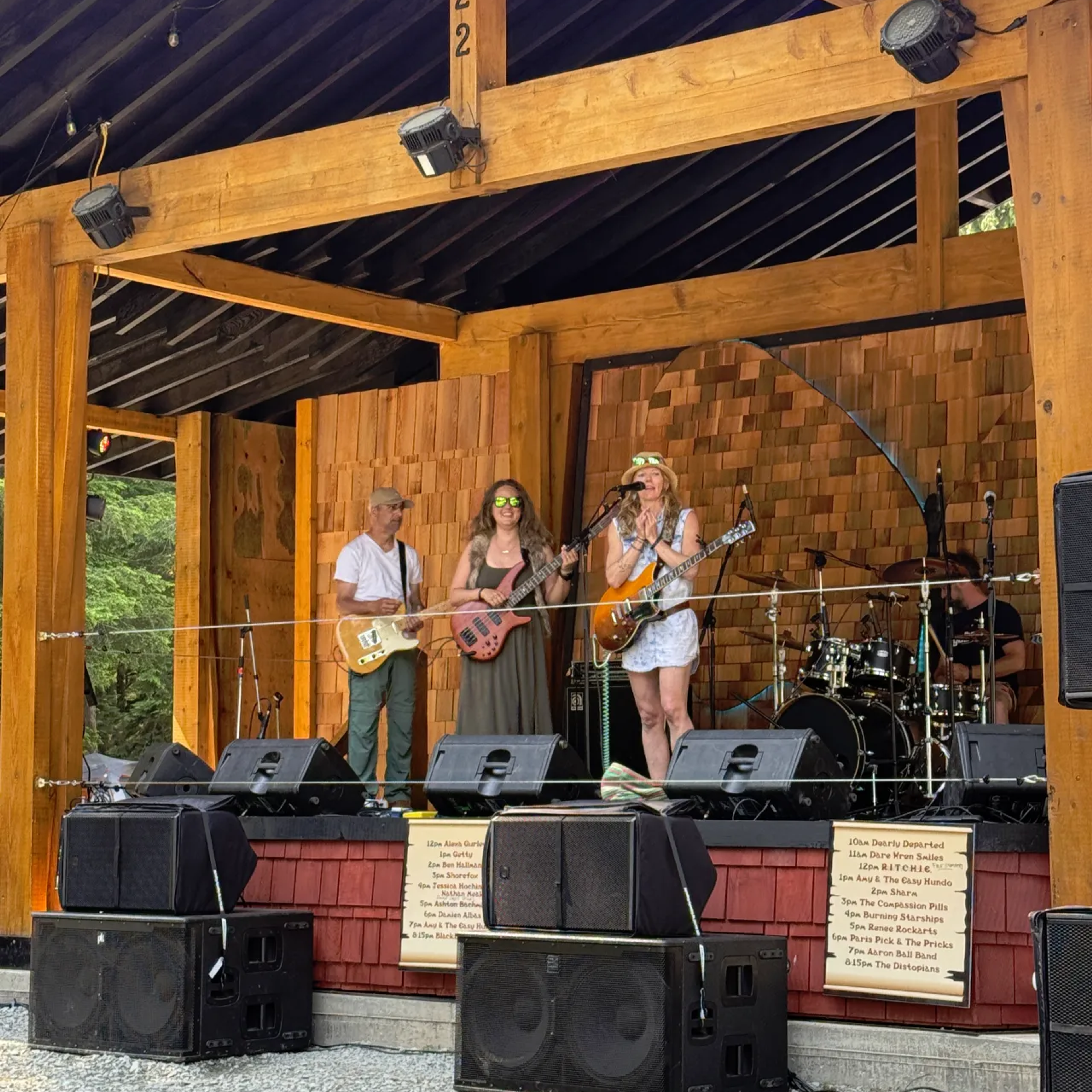 Band performing at AgeHa stage with guitars and drums in afternoon.