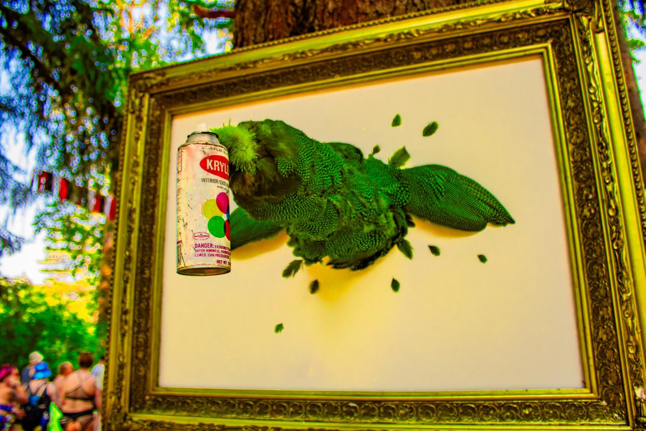 Mixed media art a vintage spray paint can, displayed outdoors at a festival.