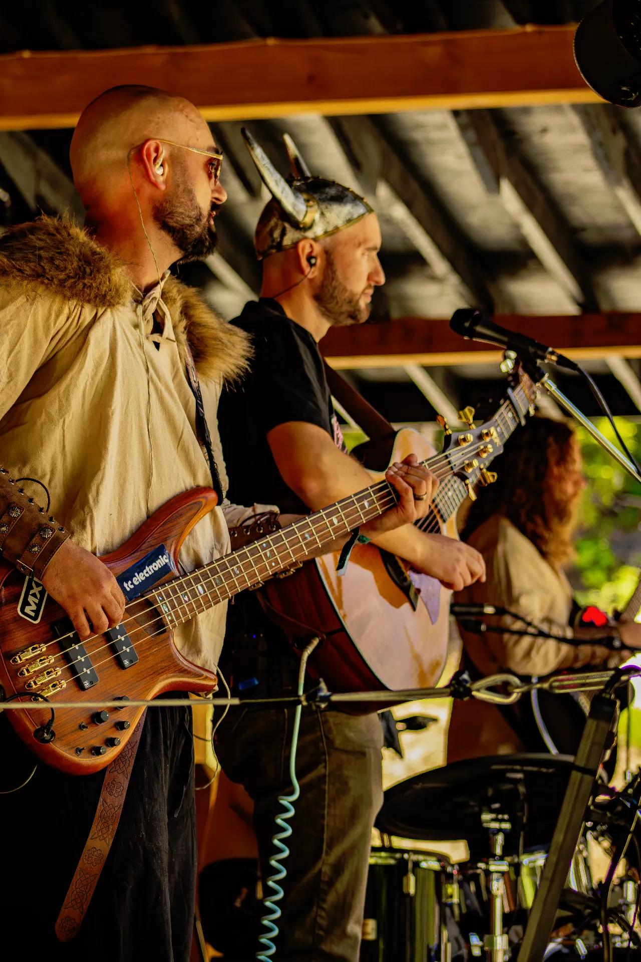 Bass and guitar duo performing at AgeHa in Viking-themed attire.