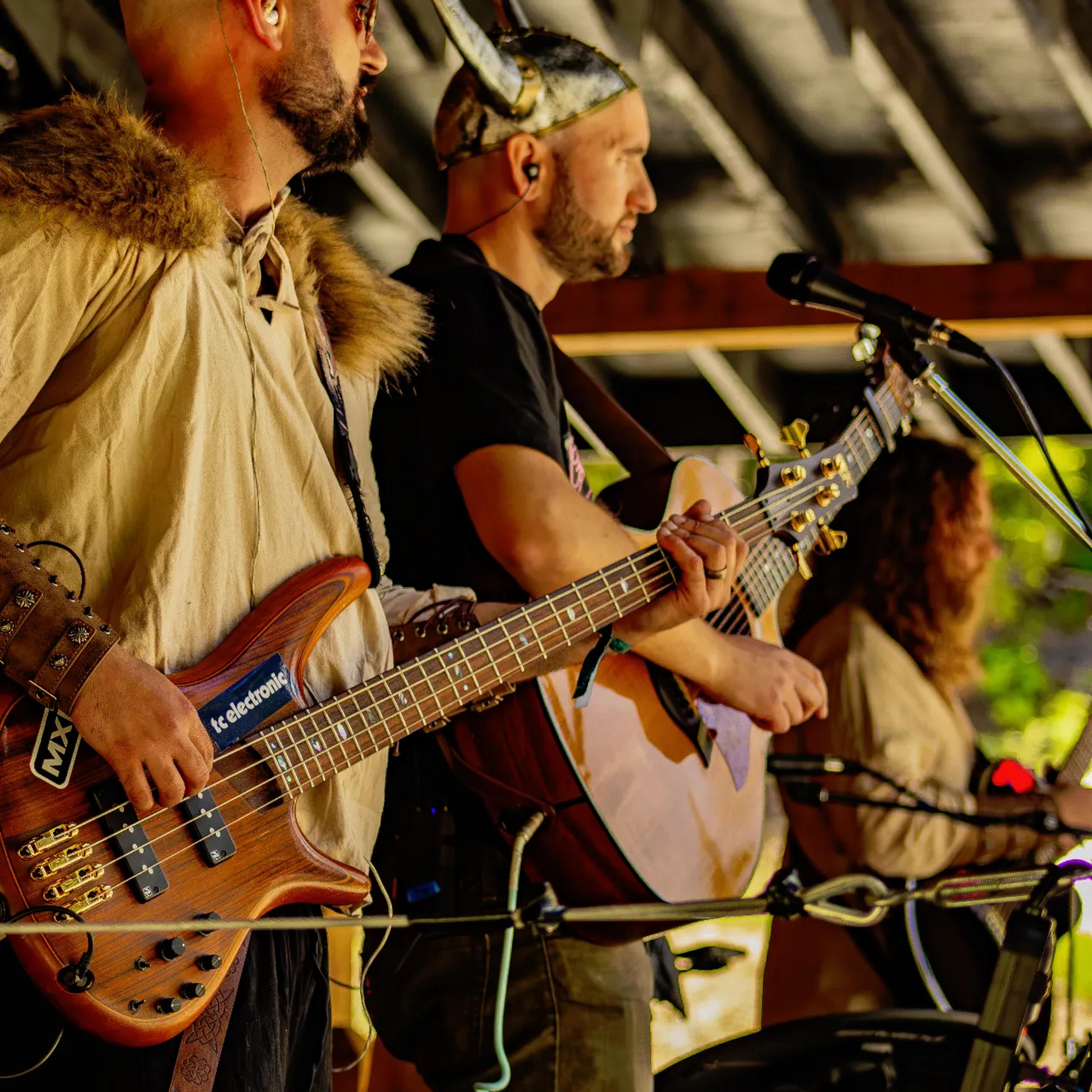 Bass and guitar duo performing at AgeHa in Viking-themed attire.