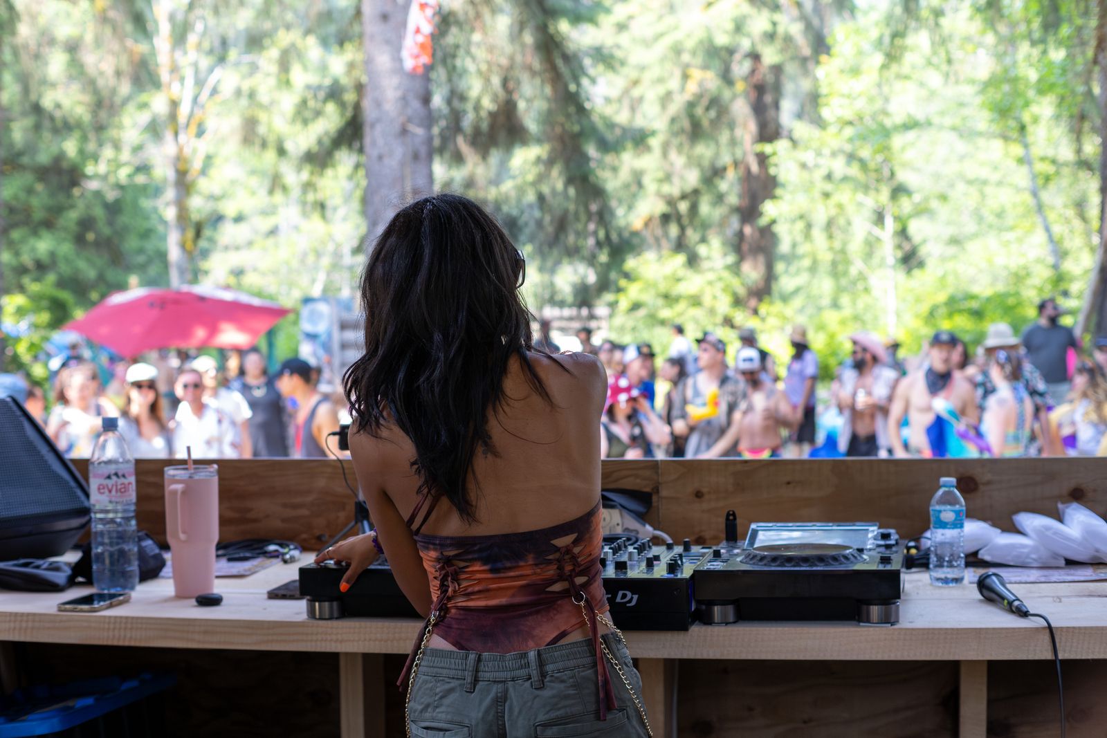 Female DJ performing to outdoor festival crowd